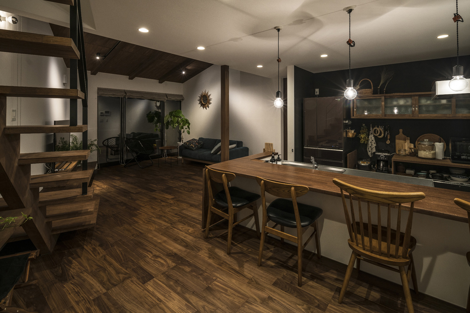 ペンダントライトと天井のダウンライトに照らされる木のカウンターキッチン・デザイン住宅 注文住宅・デザイン住宅建築実例_『CASE583 デルタ』_LDK