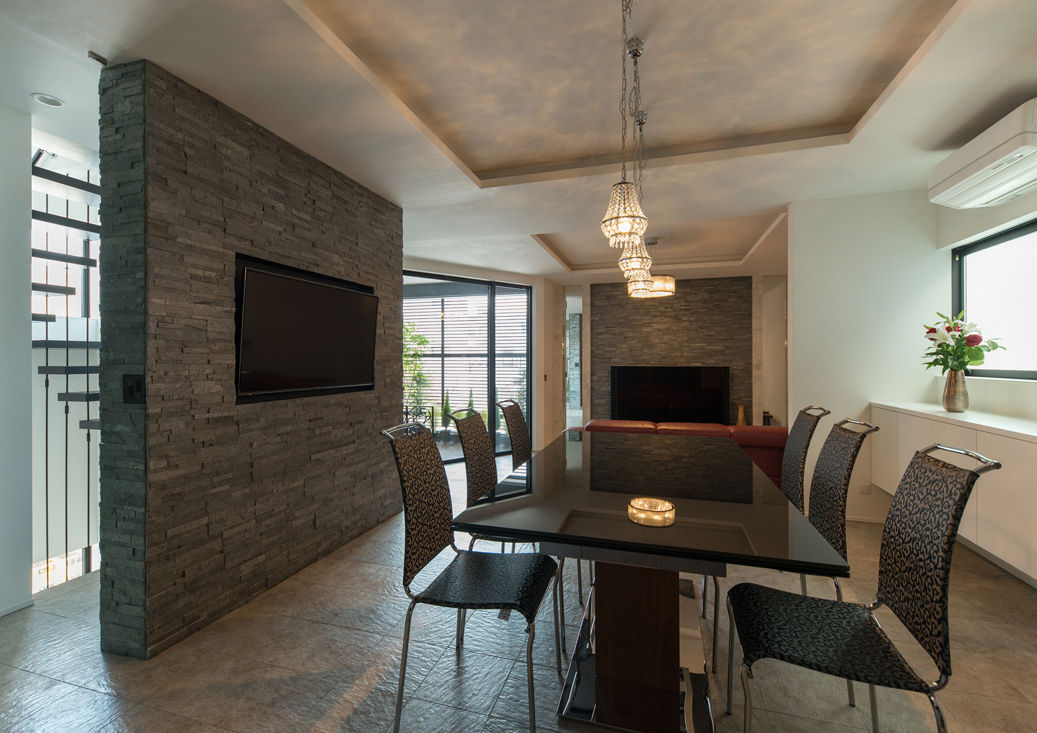 黒い石のアクセントウォールがある、折り上げ天井にペンダントライトを取り付けたLDK・デザイン住宅 注文住宅・デザイン住宅建築実例_『CASE585 いしのいえ』_LDK