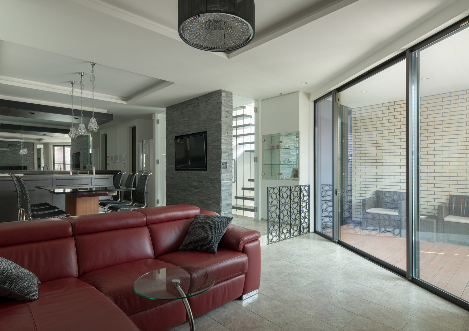 バルコニーに面した大きな窓がある赤いソファーを置いたLDK・デザイン住宅 注文住宅・デザイン住宅建築実例_『CASE585 いしのいえ』_LDK