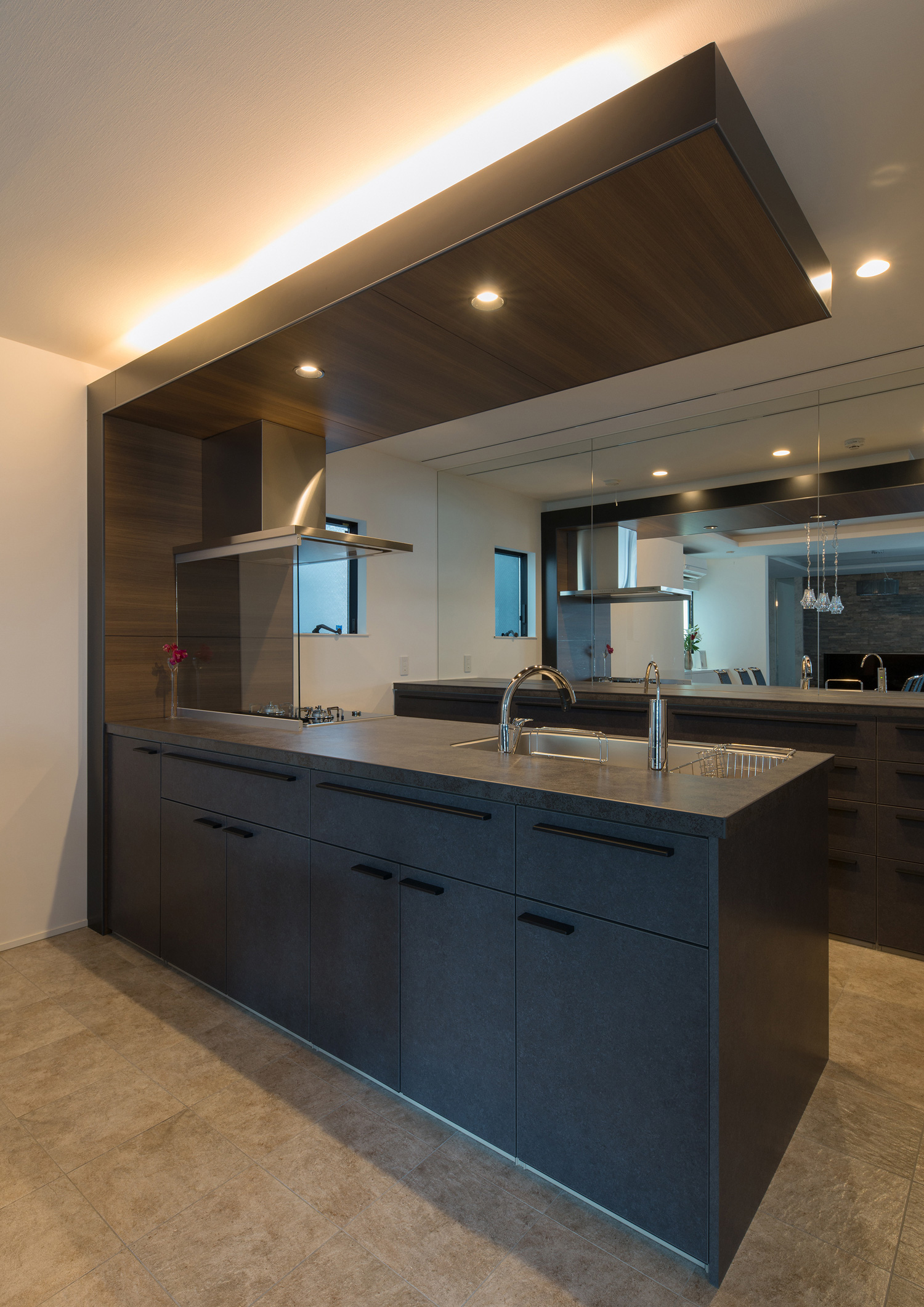 間接照明付きの下がり天井がある、背面に鏡を取り付けたキッチン・デザイン住宅 注文住宅・デザイン住宅建築実例_『CASE585 いしのいえ』_キッチン