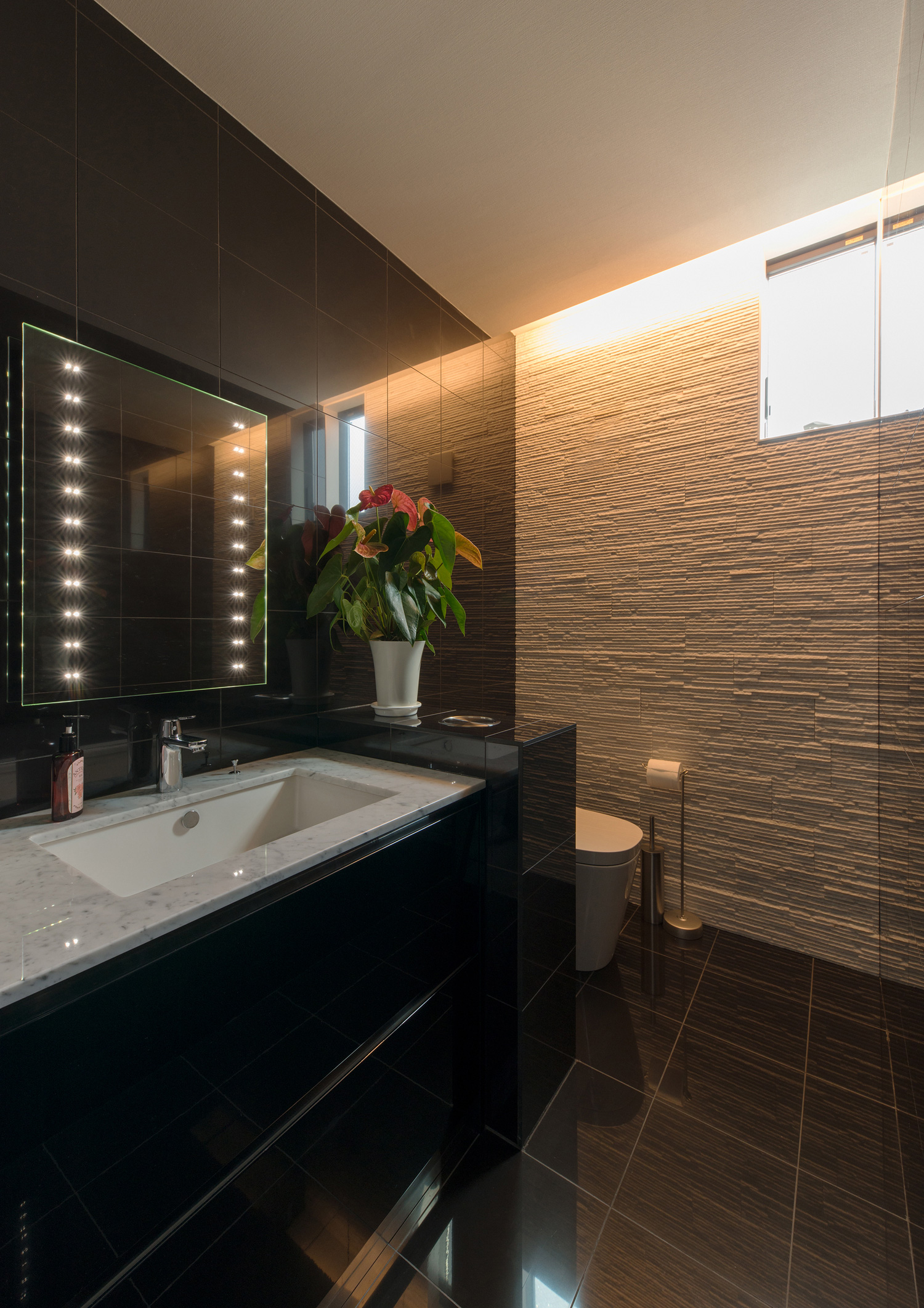 黒い壁の手洗いカウンターがある黒い床のトイレ・デザイン住宅 注文住宅・デザイン住宅建築実例_『CASE585 いしのいえ』_トイレ