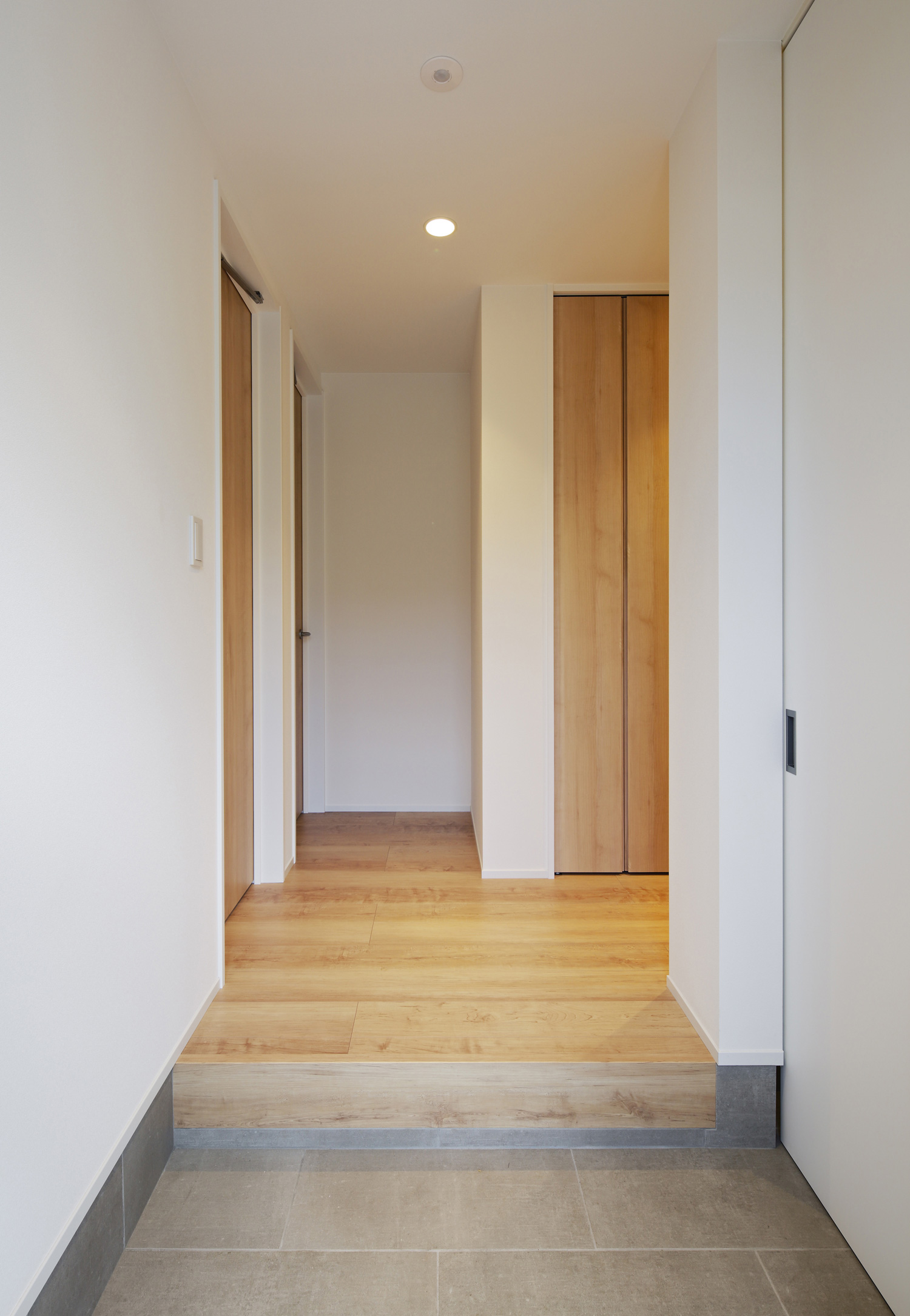 フローリングのフロアが広がるタイルの玄関・デザイン住宅 注文住宅・デザイン住宅建築実例_『CASE586 サクラクリヒノキ』_玄関