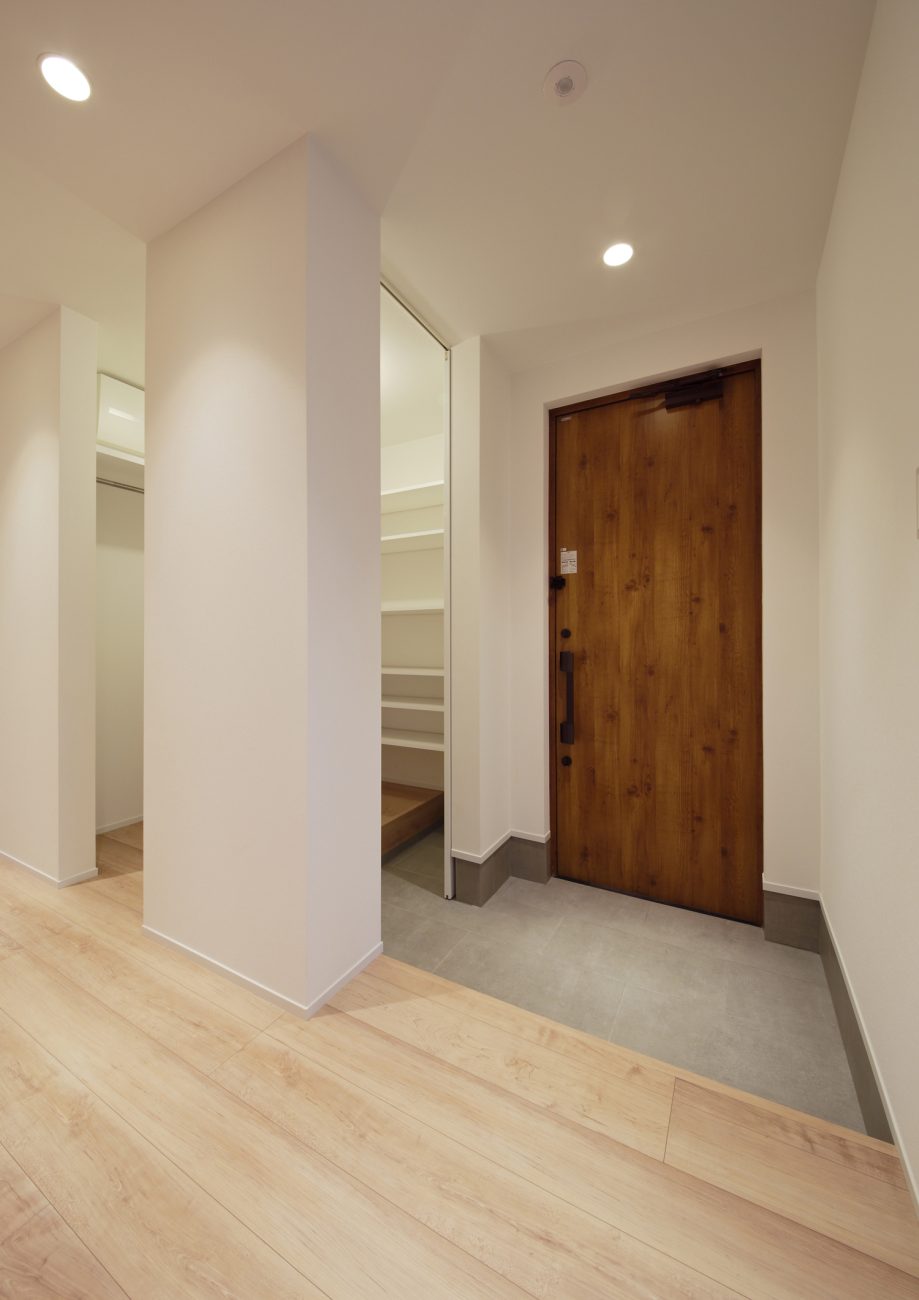 回遊式のシューズインクローゼットがある木目の玄関扉がある玄関・デザイン住宅 注文住宅・デザイン住宅建築実例_『CASE586 サクラクリヒノキ』_玄関