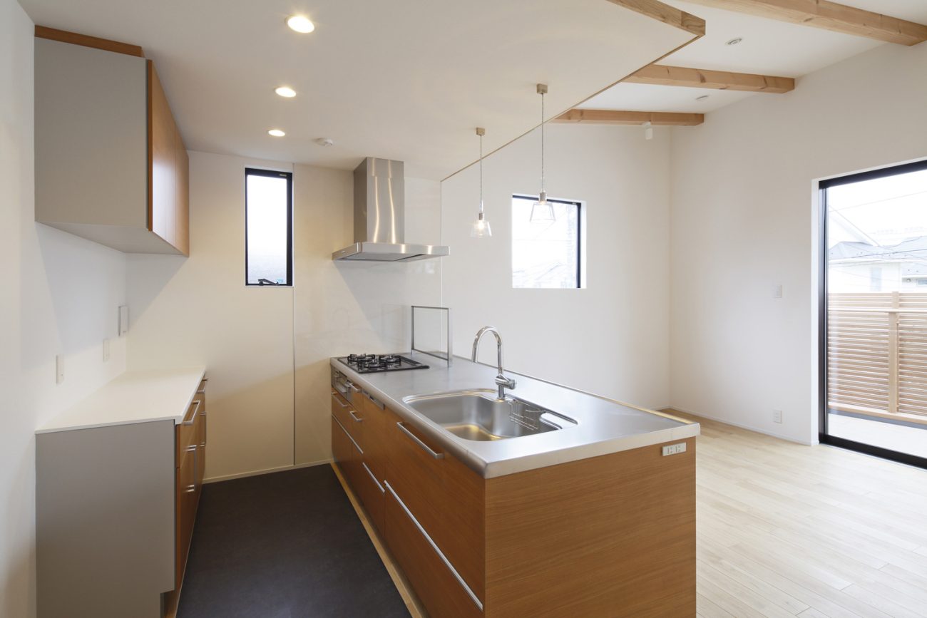 下がり天井でペンダントライトが取り付けられた木目のペニンシュラキッチン・デザイン住宅 注文住宅・デザイン住宅建築実例_『CASE586 サクラクリヒノキ』_キッチン