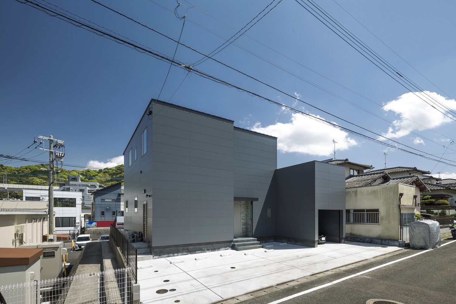 グレーの外壁でキューブ状の外観の家を斜めから見た様子・デザイン住宅 注文住宅・デザイン住宅建築実例_『CASE587 Nero』_外観