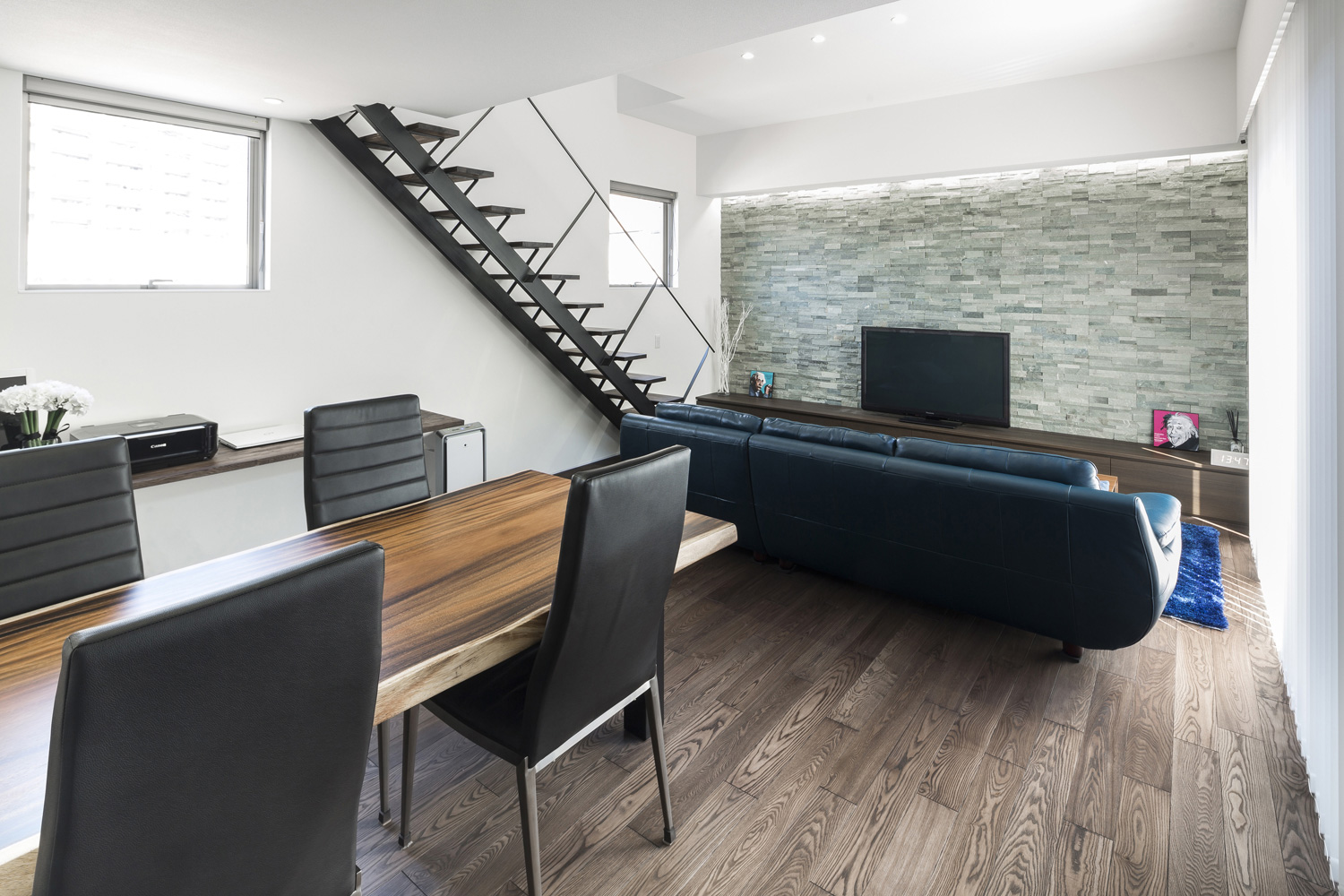 木のダイニングテーブルと青いソファーを置いたリビングイン階段のあるLDK・デザイン住宅 注文住宅・デザイン住宅建築実例_『CASE587 Nero』_LDK