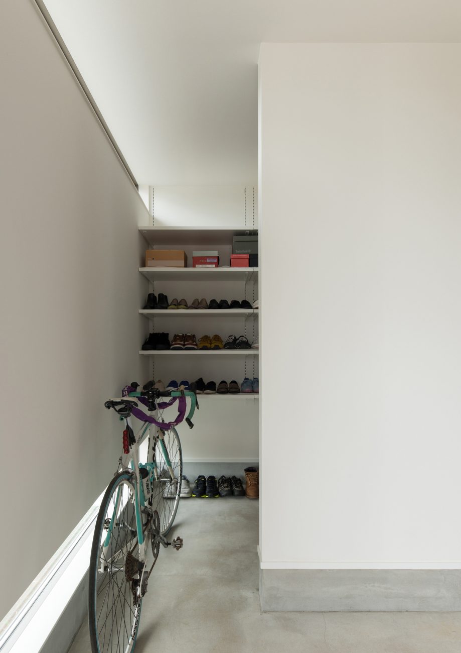 自転車を置くスペースがあるモルタルの玄関・デザイン住宅 注文住宅・デザイン住宅建築実例_『CASE588 涅の櫂』_玄関
