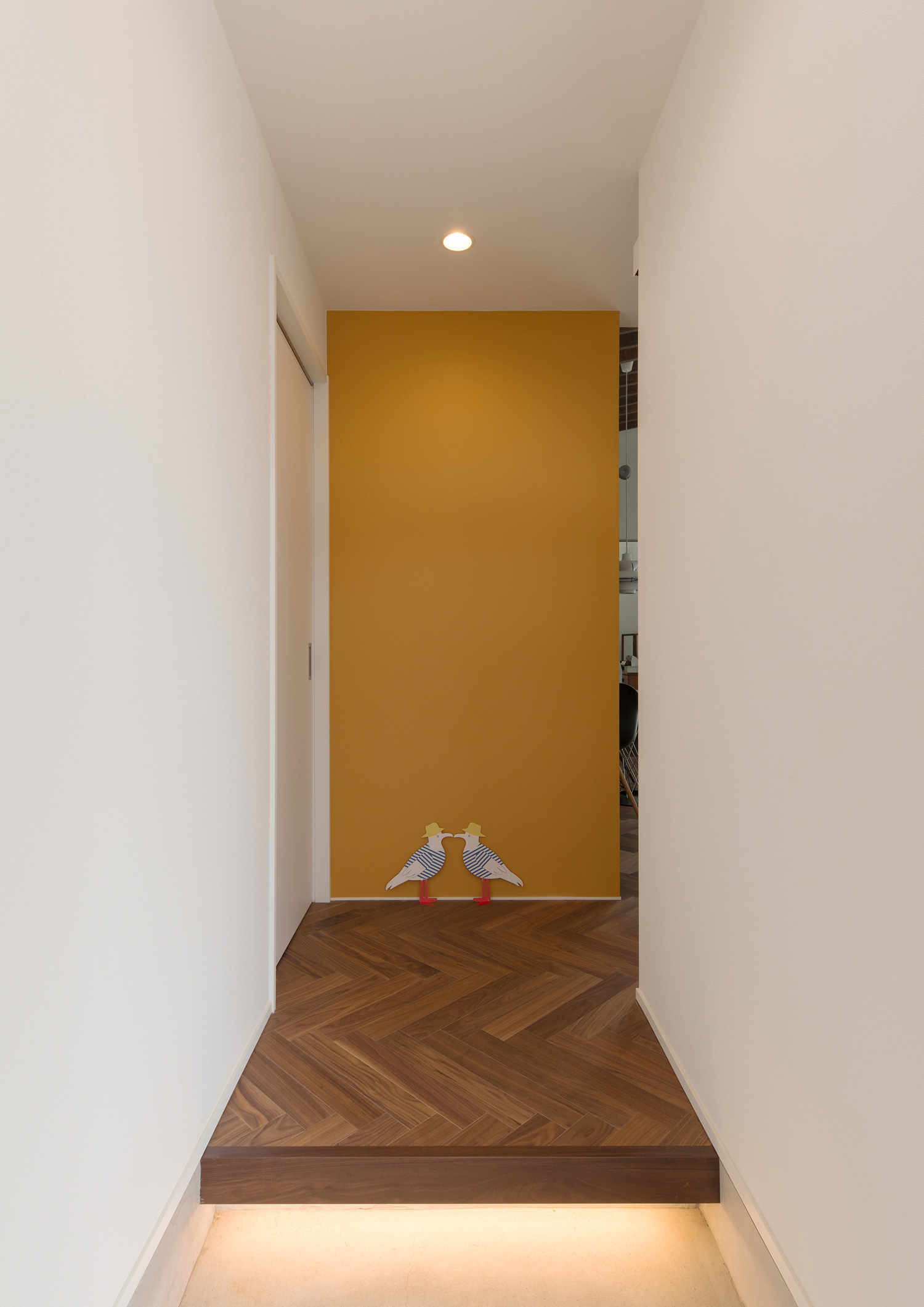 正面に黄色のクロスがあるヘリンボーン柄の床の玄関・デザイン住宅 注文住宅・デザイン住宅建築実例_『CASE588 涅の櫂』_玄関