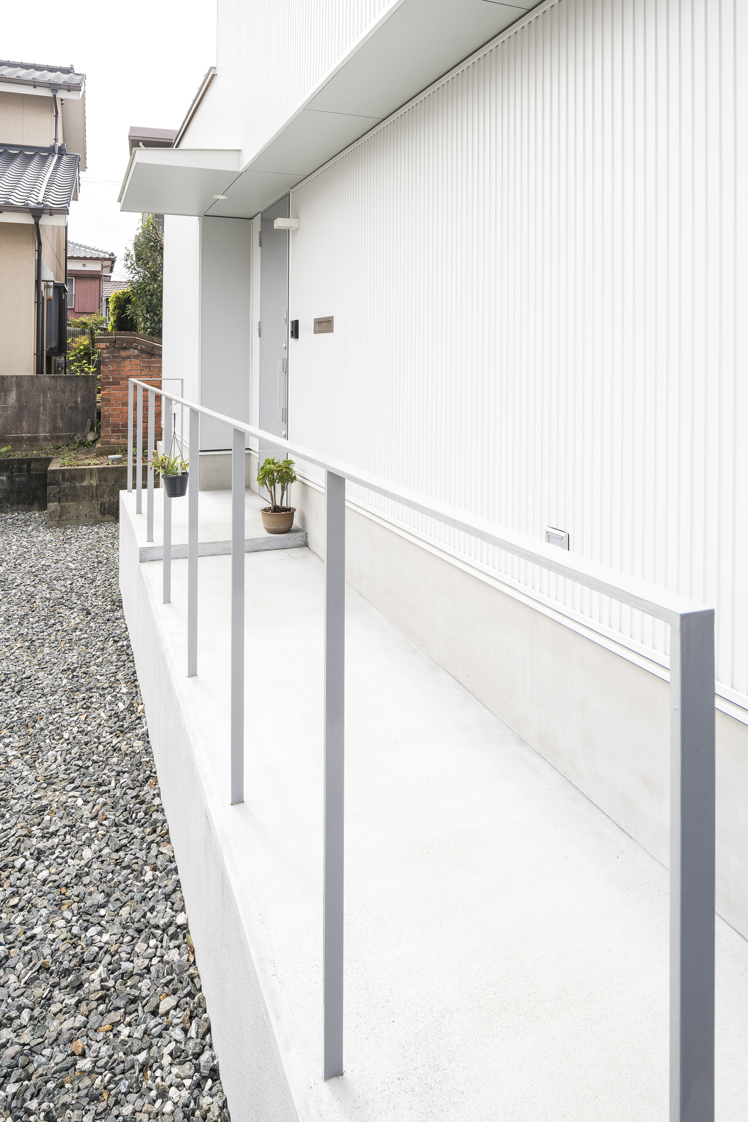 アルミの手すり付きのスロープのアプローチがある白い外壁の家・デザイン住宅 注文住宅・デザイン住宅建築実例_『CASE589 pinwheel』_外観