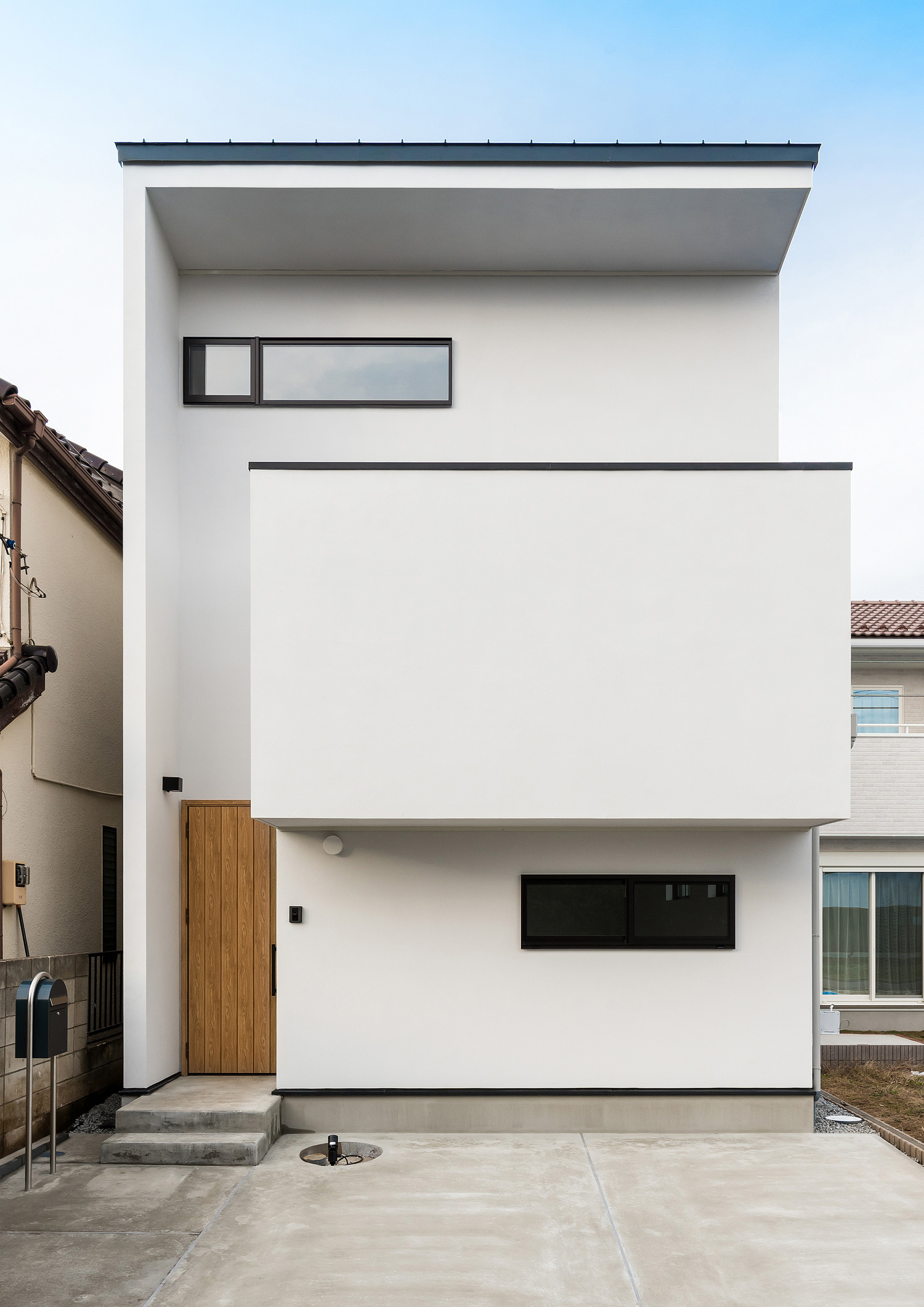 バルコニーや木の玄関扉がある白い外壁の家・デザイン住宅 注文住宅・デザイン住宅建築実例_『CASE590 つなぐ家』_外観