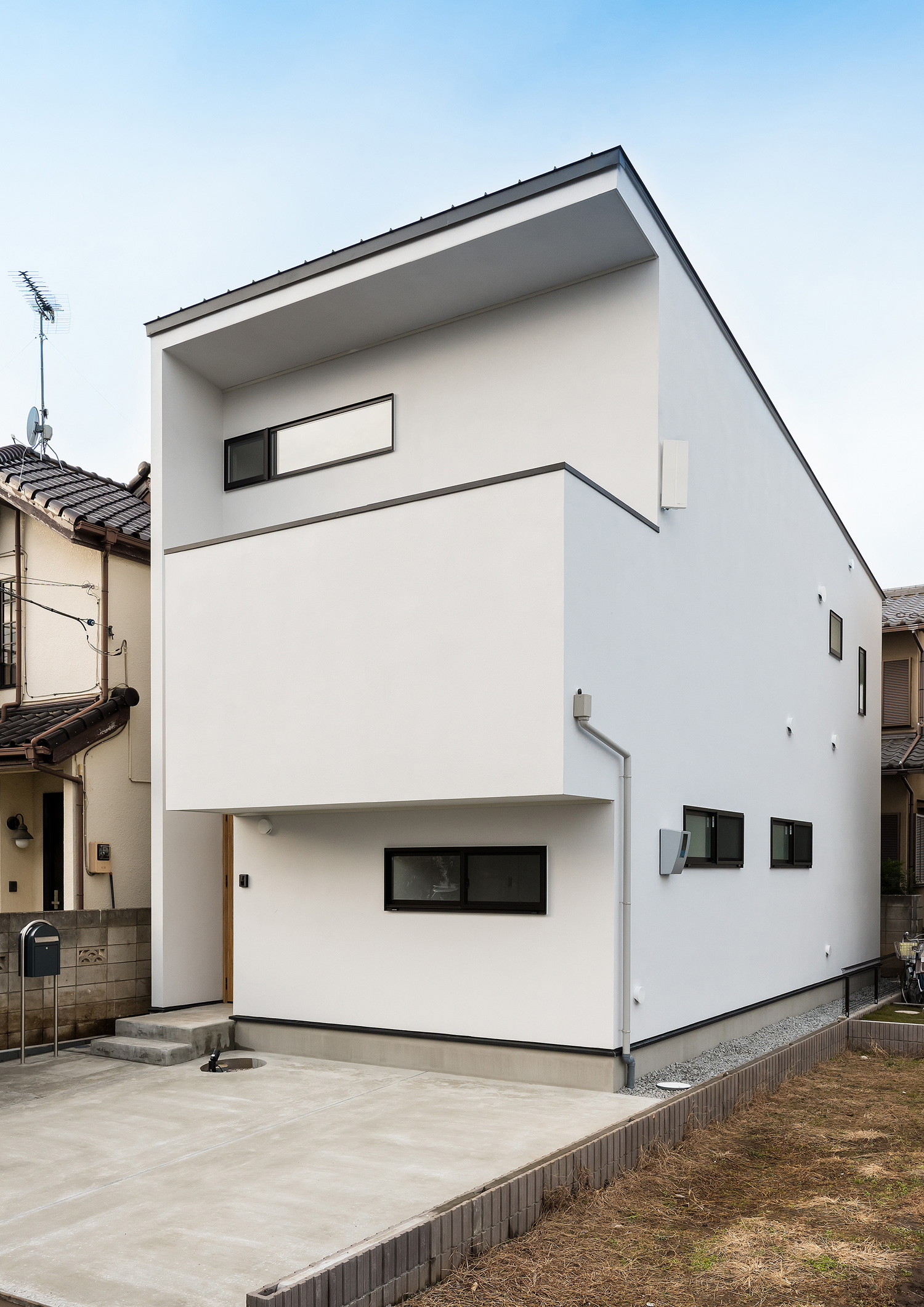 横長のスリット窓が取り付けられた白い外壁のバルコニーのある家・デザイン住宅 注文住宅・デザイン住宅建築実例_『CASE590 つなぐ家』_外観