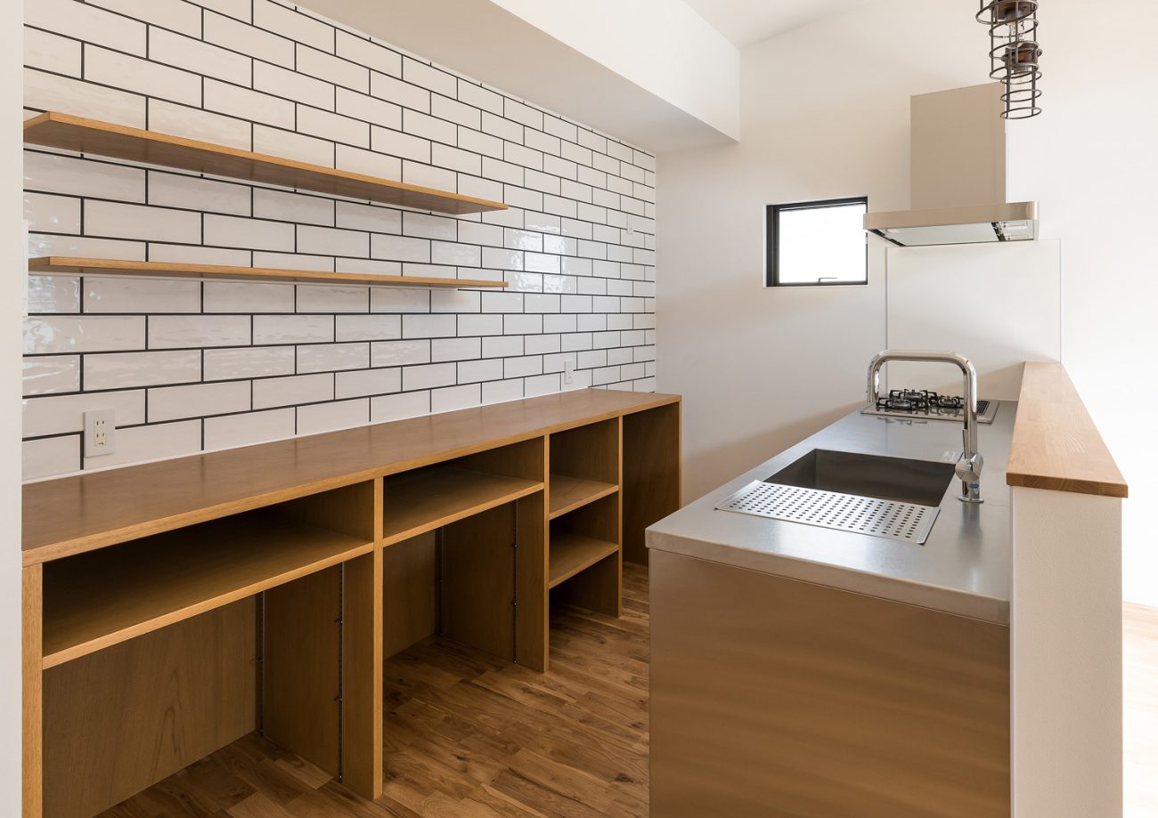 カップボードの壁がタイル貼りになった腰壁付きのキッチン 注文住宅・デザイン住宅建築実例_『CASE590 つなぐ家』_キッチン