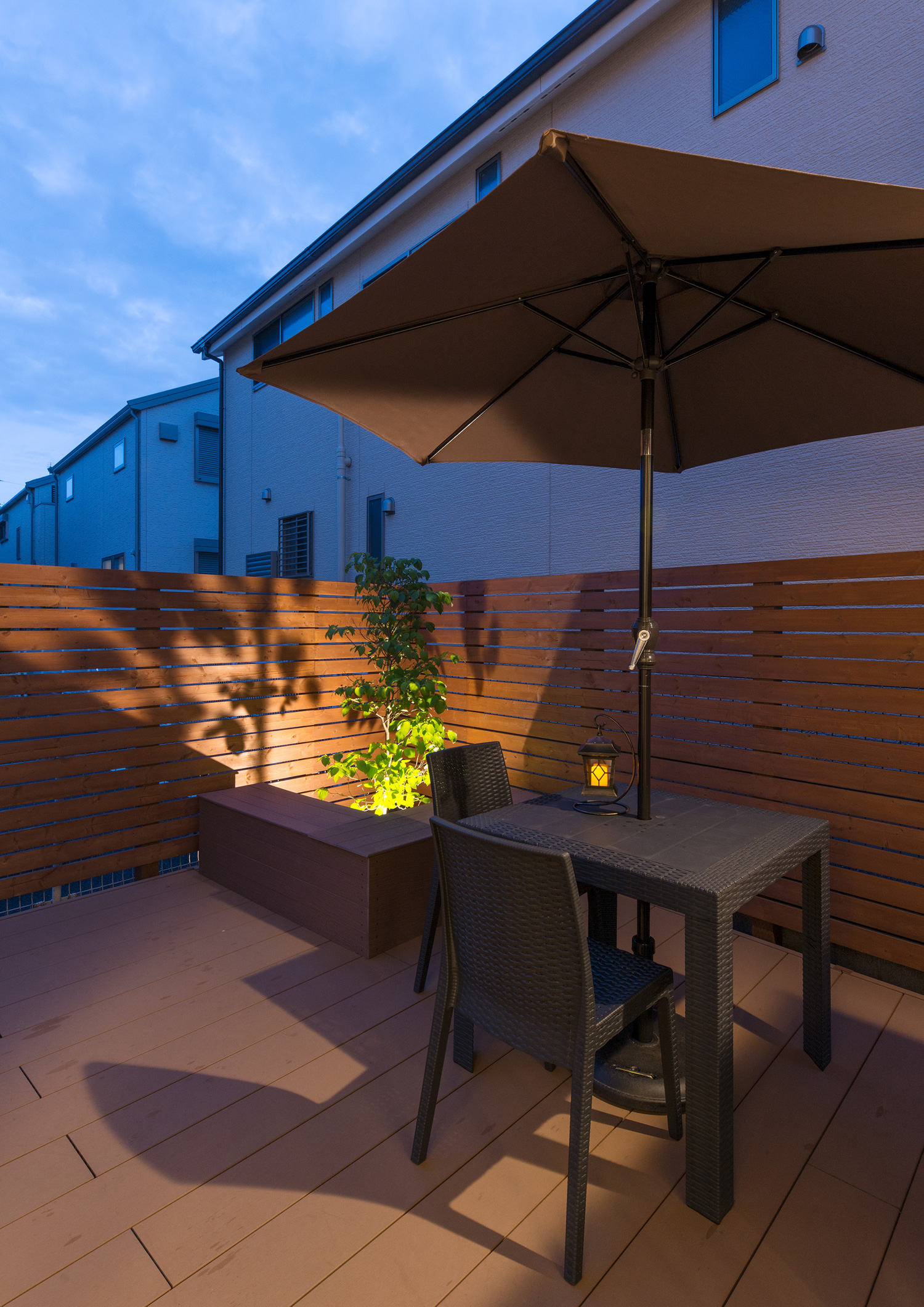 机やライトアップされた植栽が置かれた木の目隠しがあるテラス・デザイン住宅 注文住宅・デザイン住宅建築実例_『CASE595 あかりを織る家』_テラス・バルコニー