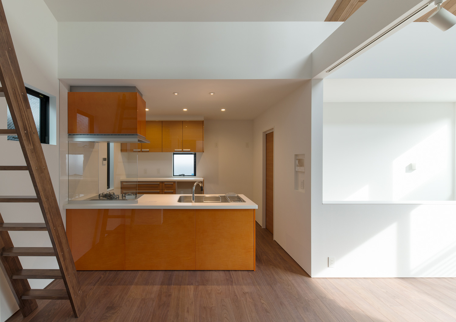 オレンジのキッチンがあるリビングイン階段のあるLDK・デザイン住宅 注文住宅・デザイン住宅建築実例_『CASE596 【edge】』_キッチン