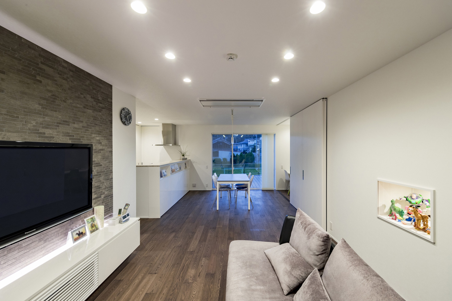 ベランダに面した窓があるグレーのフローリングのLDK・デザイン住宅 注文住宅・デザイン住宅建築実例_『CASE598 爽　～風と光～』_LDK