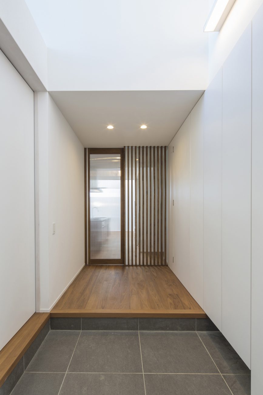 正面にルーバーの壁とガラス扉がある吹き抜けの玄関・デザイン住宅 注文住宅・デザイン住宅建築実例_『CASE600 ソラの家』_玄関