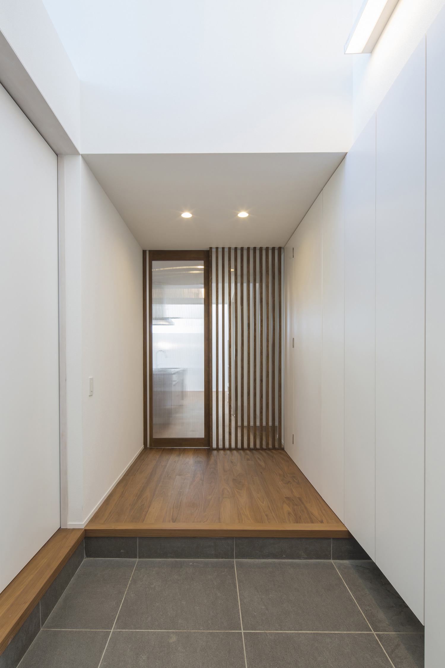 正面にルーバーの壁とガラス扉がある吹き抜けの玄関・デザイン住宅 注文住宅・デザイン住宅建築実例_『CASE600 ソラの家』_玄関