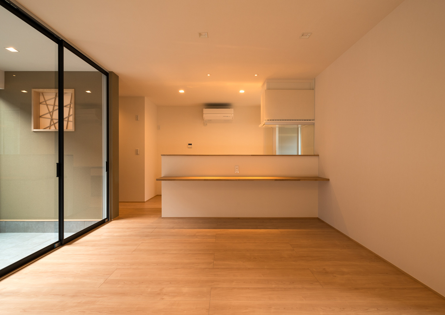 腰壁に木のカウンターが取り付けられたキッチンがあるLDK・デザイン住宅 注文住宅・デザイン住宅建築実例_『CASE601 ドマノイエ』_LDK