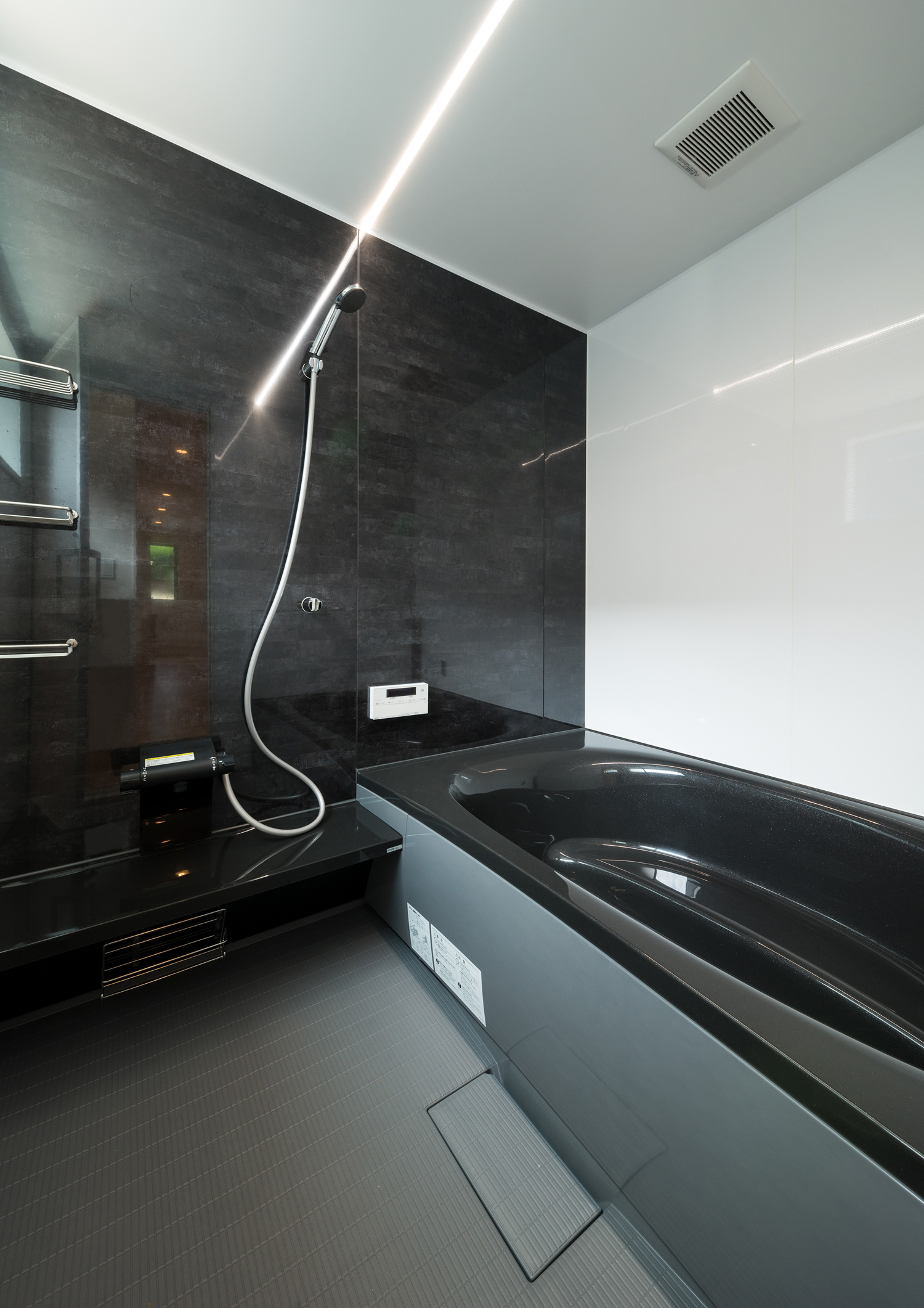 黒いバスタブと壁で、線状の照明が取り付けられた浴室・デザイン住宅 注文住宅・デザイン住宅建築実例_『CASE601 ドマノイエ』_浴室・洗面所
