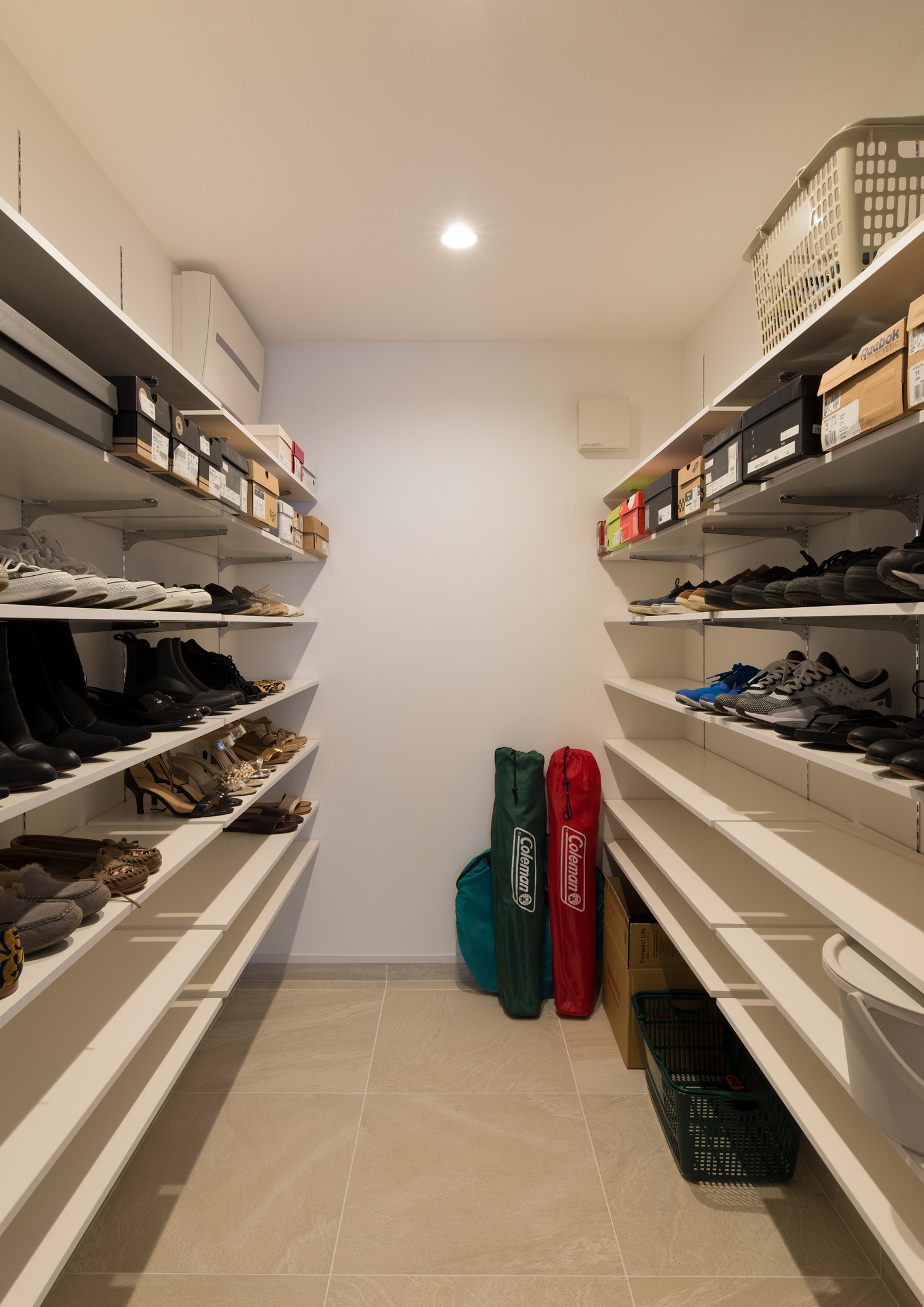 壁付けの棚に靴が並べられたキャンプ用品も収納できるシューズインクローゼット・デザイン住宅 注文住宅・デザイン住宅建築実例_『CASE602 WOODボックスハウス』_玄関