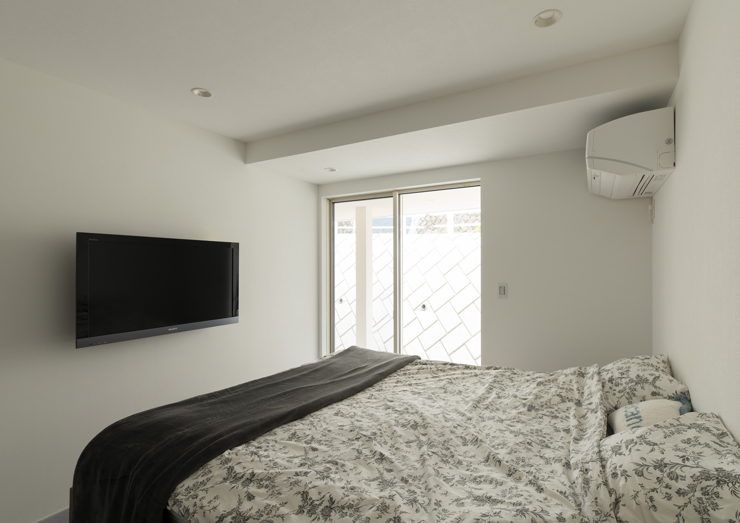 壁付けテレビと、外に繋がる窓がある寝室・デザイン住宅 注文住宅・デザイン住宅建築実例_『CASE602 WOODボックスハウス』_寝室