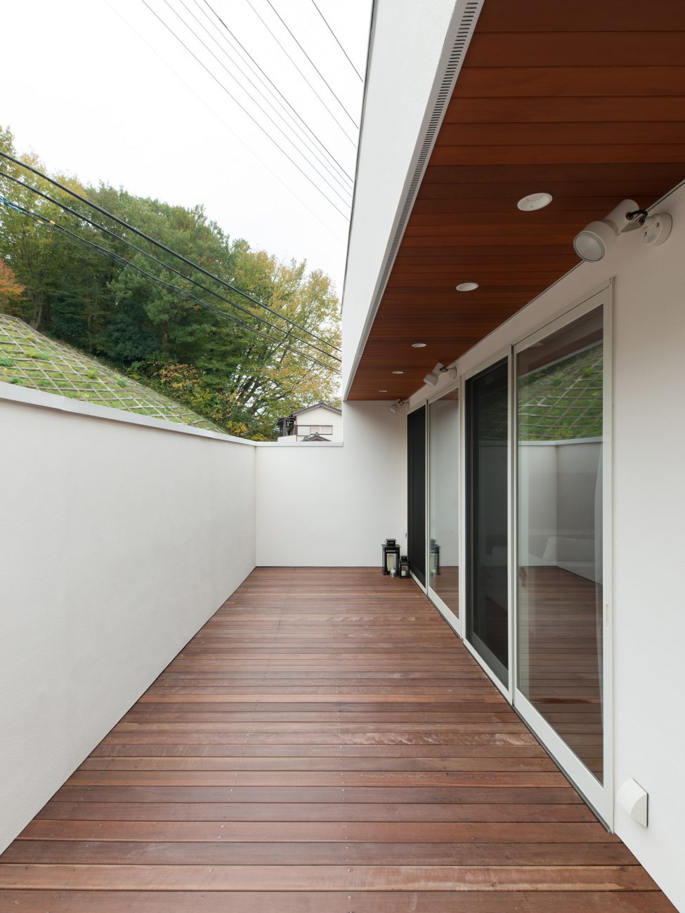 白い目隠し壁がある木目の軒天井のバルコニー・デザイン住宅 注文住宅・デザイン住宅建築実例_『CASE602 WOODボックスハウス』_テラス・バルコニー