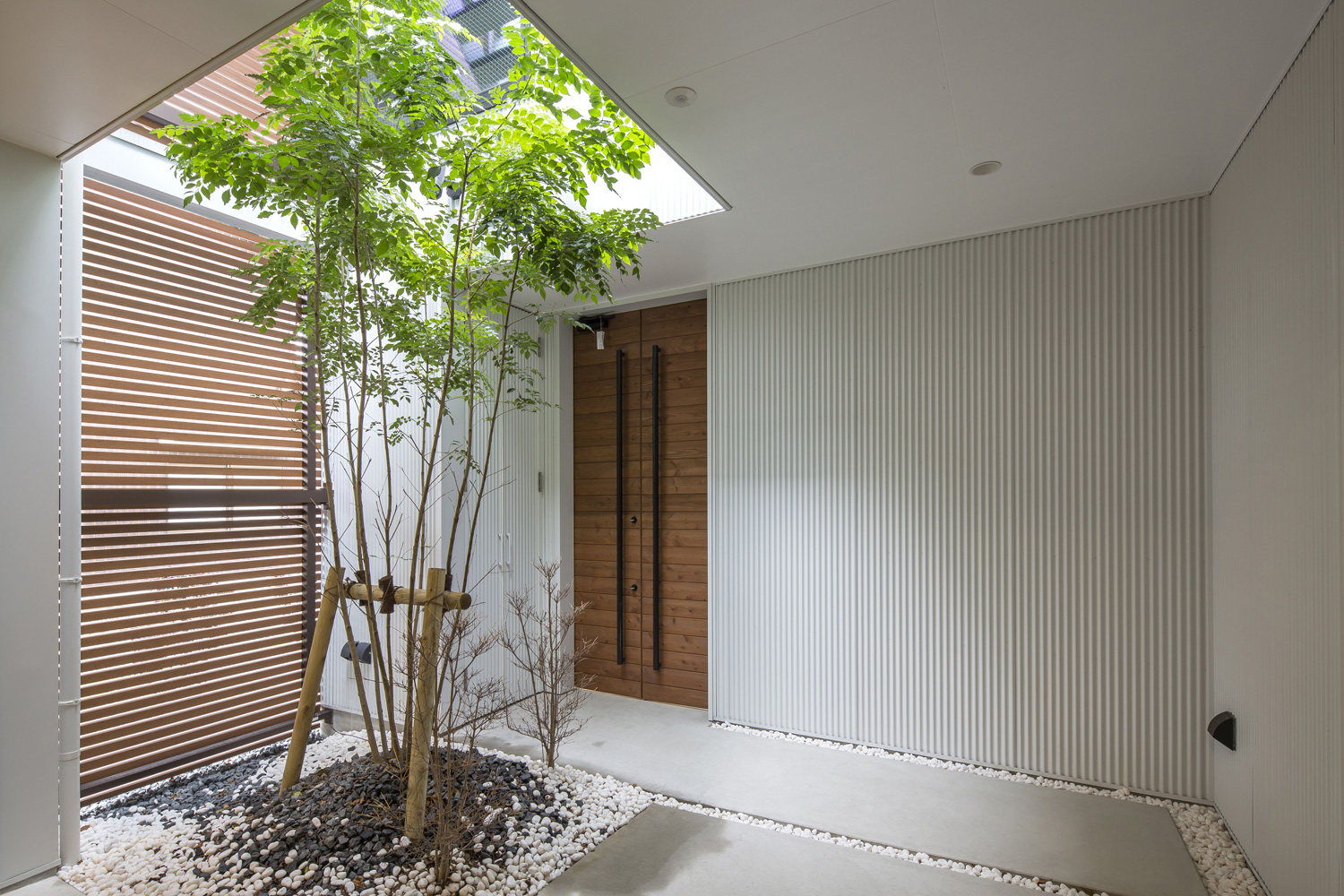 シンボルツリーがある部分が吹き抜けとなった玄関ポーチ・デザイン住宅 注文住宅・デザイン住宅建築実例_『CASE603 Flügel』_外観