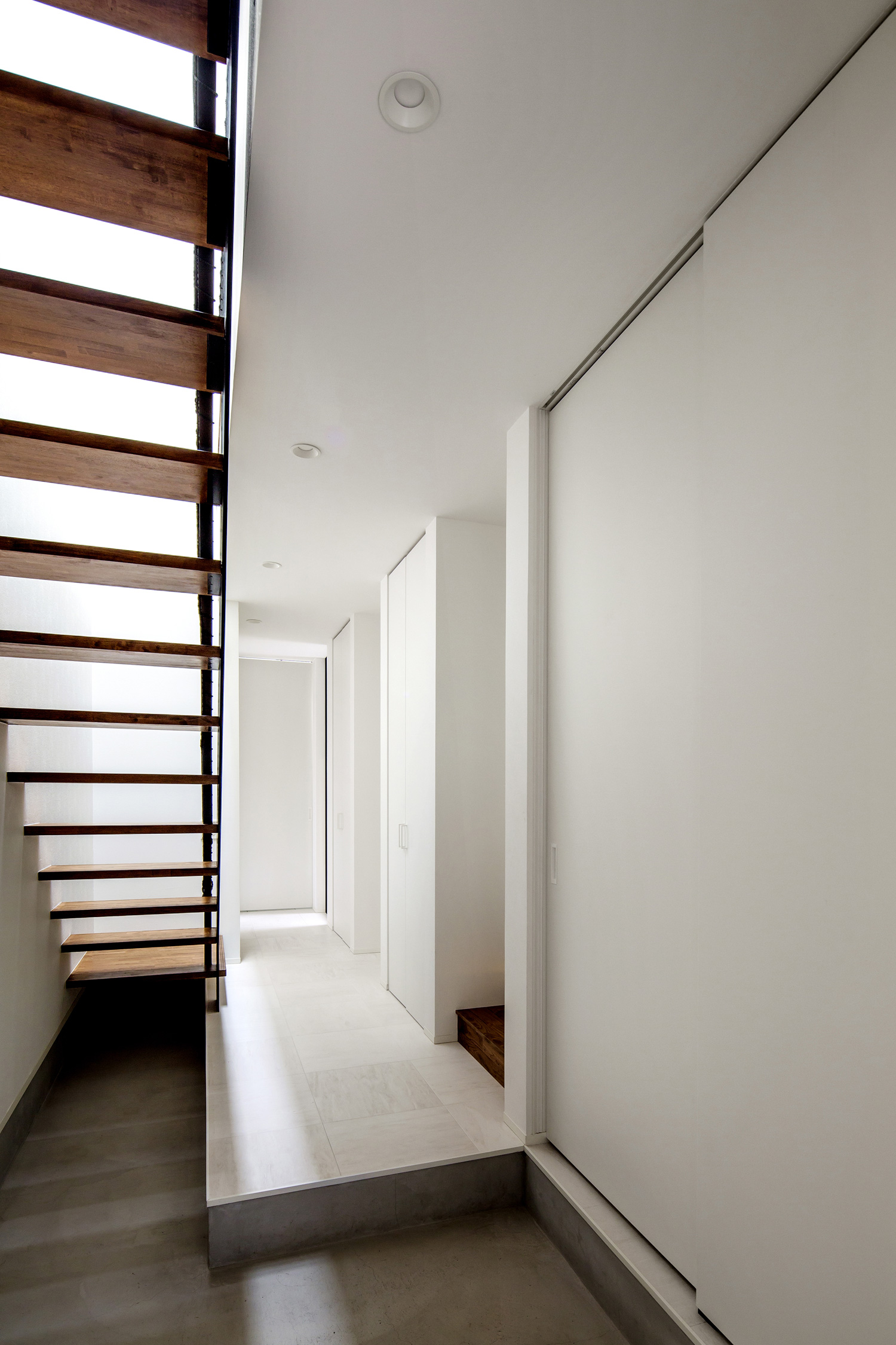 白い壁の空間に木のスケルトン階段がある玄関・デザイン住宅 注文住宅・デザイン住宅建築実例_『CASE603 Flügel』_玄関