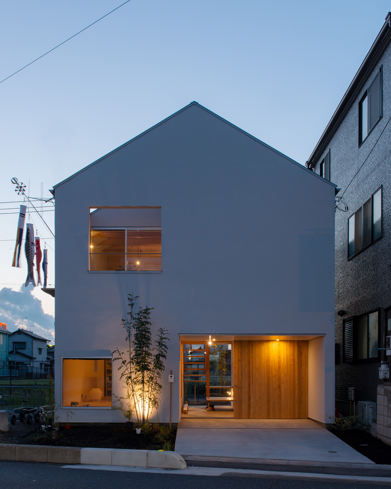 玄関の軒天井の照明や、シンボルツリーを照らす屋外照明がある三角屋根の家・デザイン住宅 注文住宅・デザイン住宅建築実例_『CASE605 切妻のsign』_外観