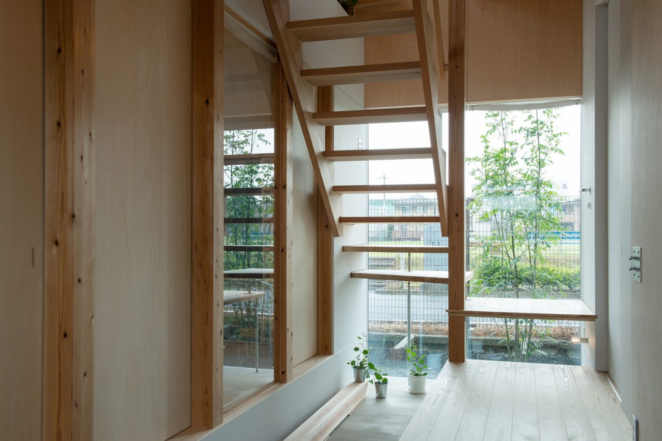 スケルトン階段越しにシンボルツリーが見える窓がある土間の玄関・デザイン住宅 注文住宅・デザイン住宅建築実例_『CASE605 切妻のsign』_玄関