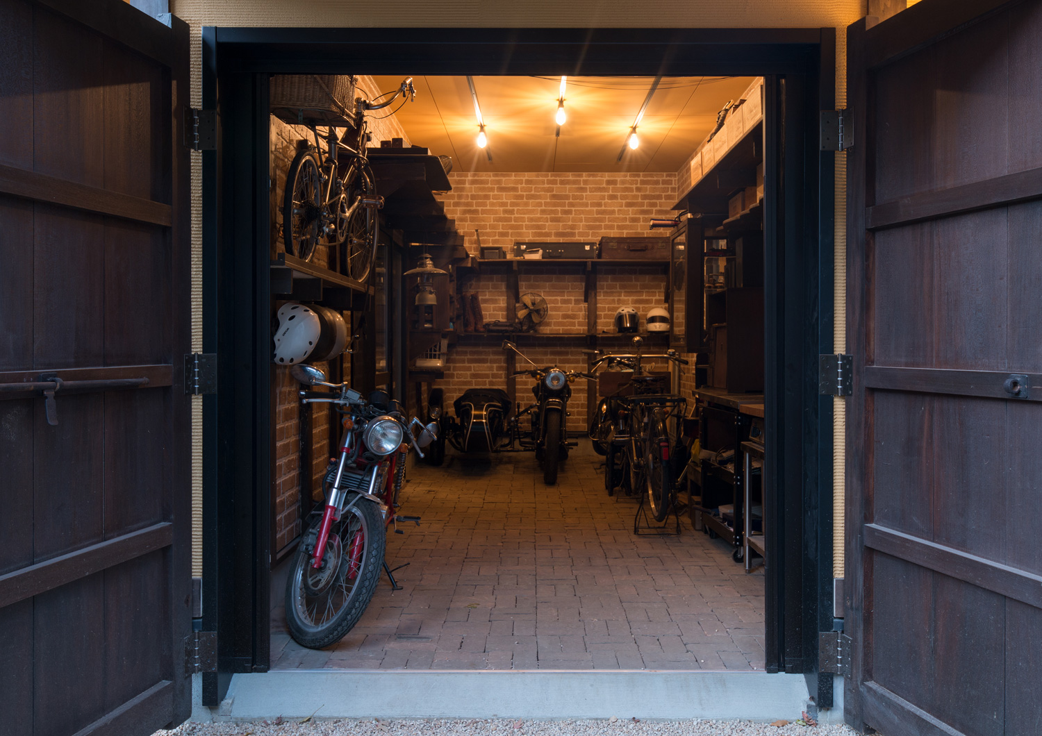 レンガ風の壁紙を貼った扉付きのガレージ・デザイン住宅 注文住宅・デザイン住宅建築実例_『CASE607 懐（ふところ）』_ガレージ