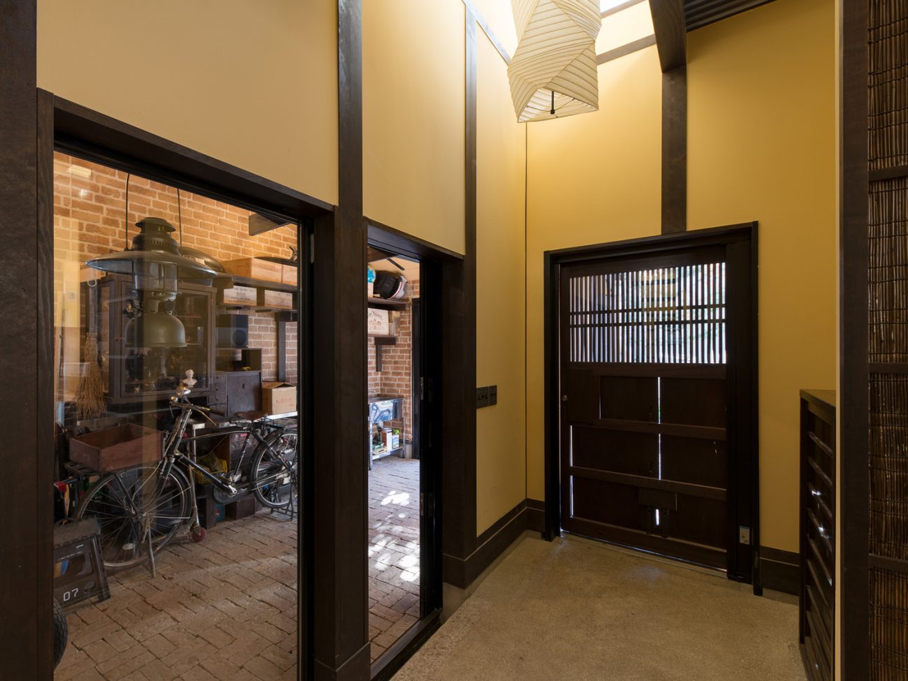 ガラス越しにガレージが見える吹き抜けの土間玄関・デザイン住宅 注文住宅・デザイン住宅建築実例_『CASE607 懐（ふところ）』_玄関