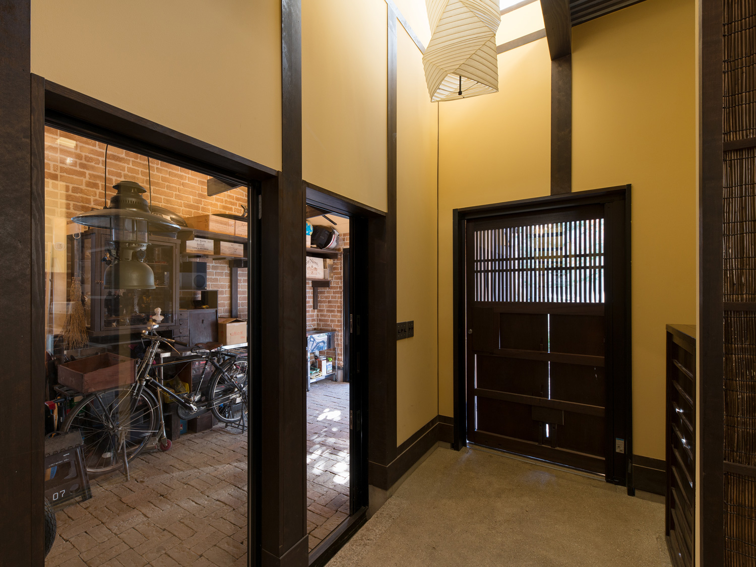 ガラス越しにガレージが見える吹き抜けの土間玄関・デザイン住宅 注文住宅・デザイン住宅建築実例_『CASE607 懐（ふところ）』_玄関