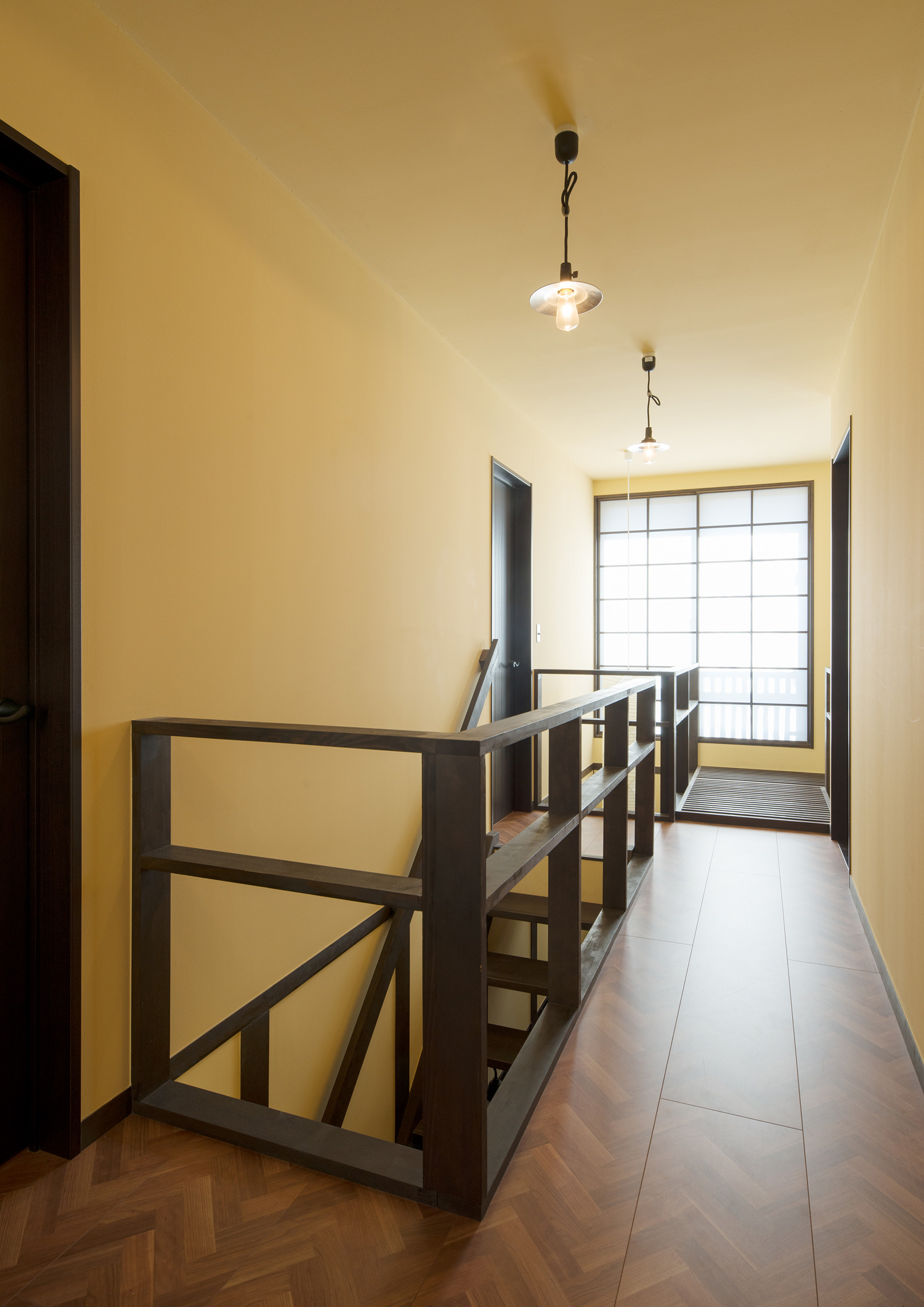 吹き抜けに面した、ヘリンボーン柄の床で黄色い壁の廊下・デザイン住宅 注文住宅・デザイン住宅建築実例_『CASE607 懐（ふところ）』_廊下