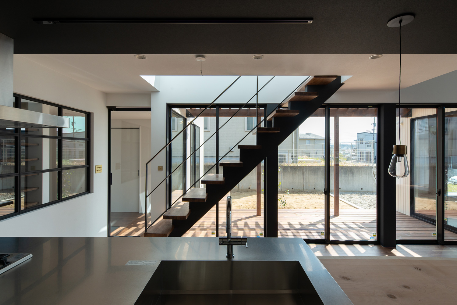 ウッドデッキに面した大開口窓の前にスケルトン階段があるLDK・デザイン住宅 注文住宅・デザイン住宅建築実例_『CASE609 パーゴラの家』_LDK