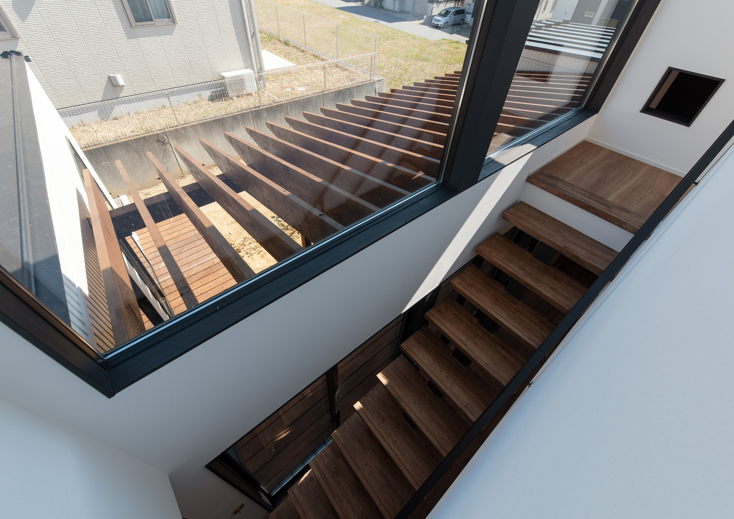 ウッドデッキのパーゴラが窓から見える階段部分・デザイン住宅 注文住宅・デザイン住宅建築実例_『CASE609 パーゴラの家』_階段