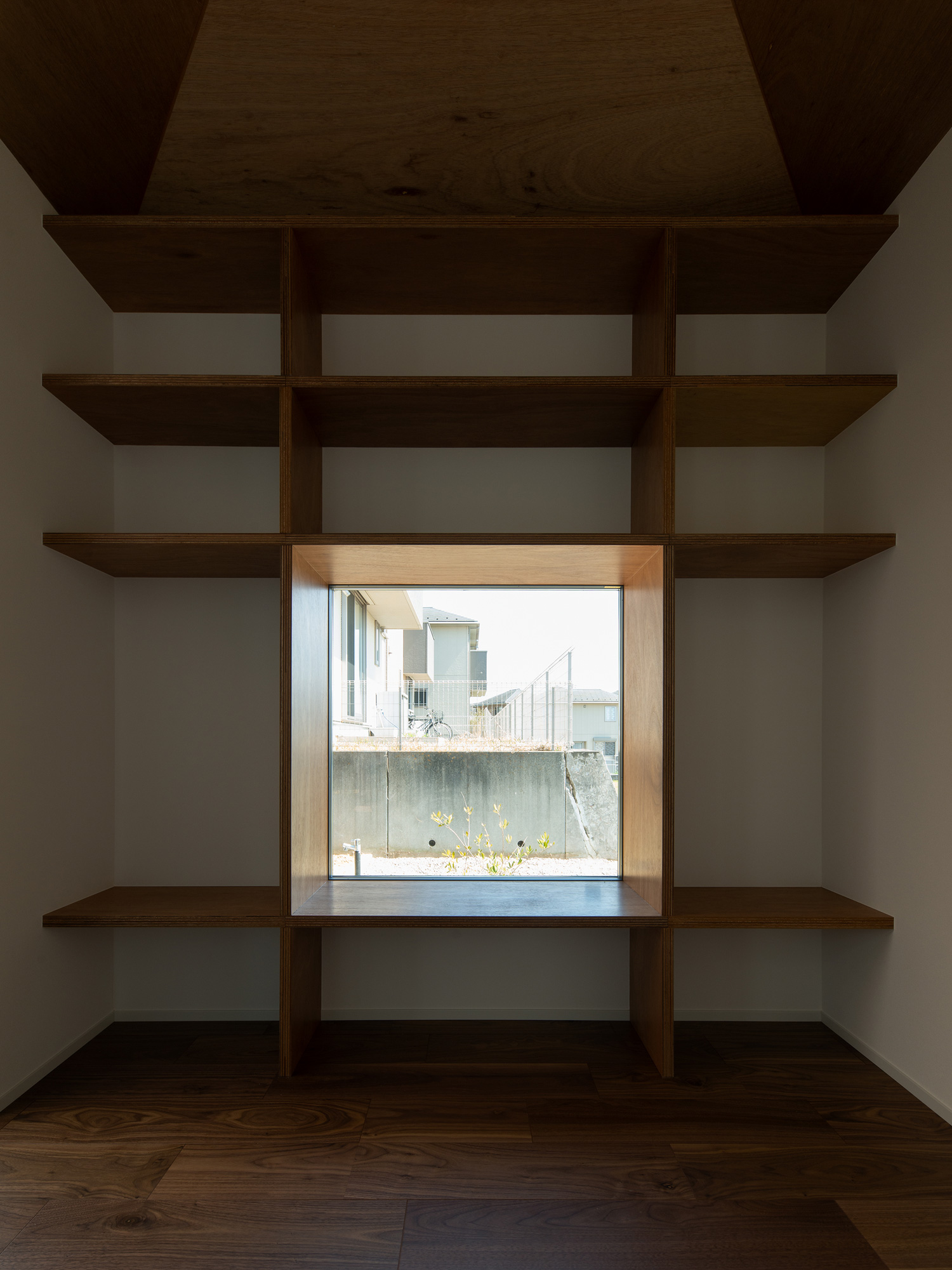 正方形の窓を囲むように壁付け棚が取り付けられた書斎・デザイン住宅 注文住宅・デザイン住宅建築実例_『CASE609 パーゴラの家』_書斎