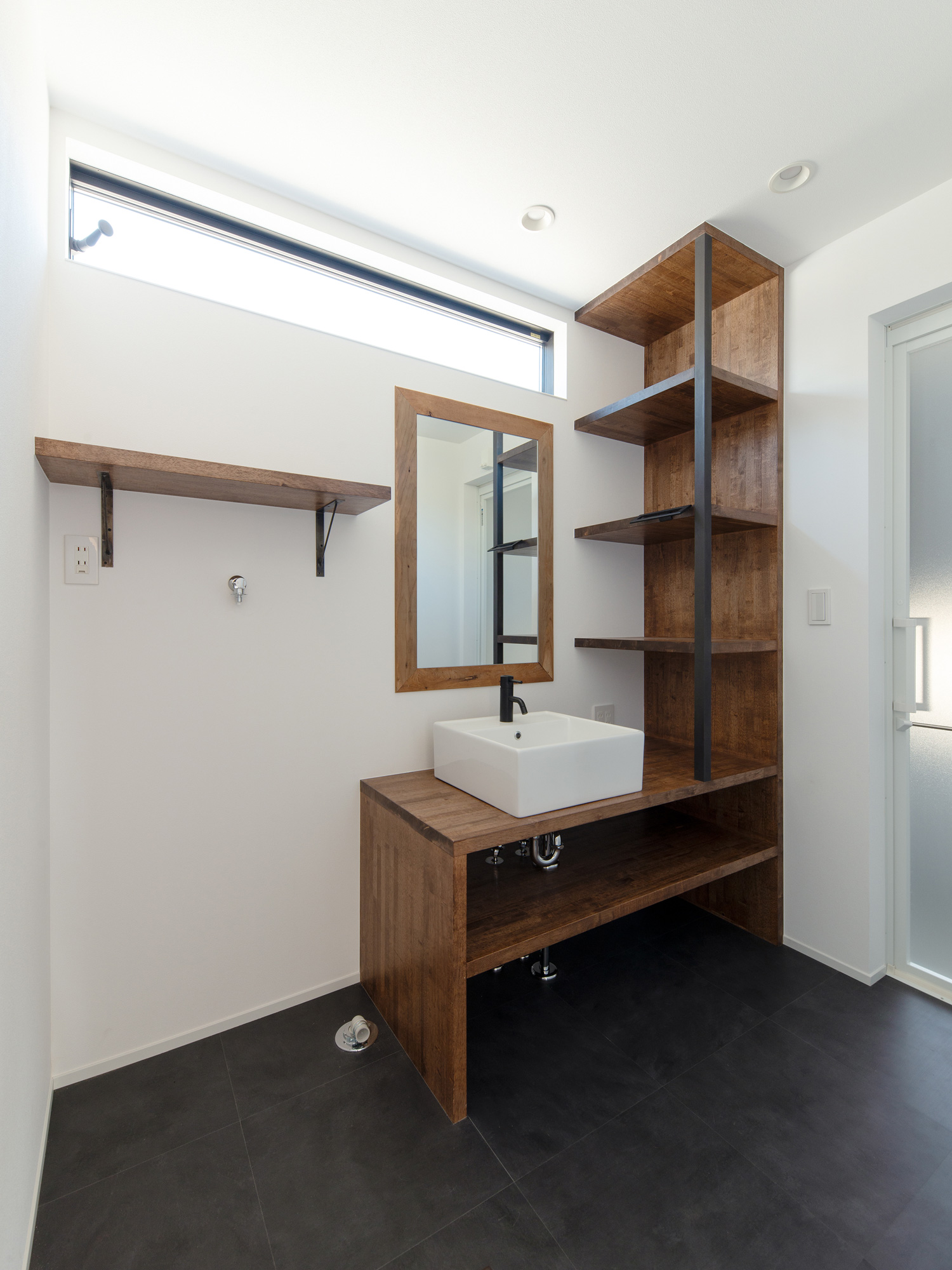 洗面台と一体化した木製の壁付け棚がある洗面所・デザイン住宅 注文住宅・デザイン住宅建築実例_『CASE609 パーゴラの家』_浴室・洗面所