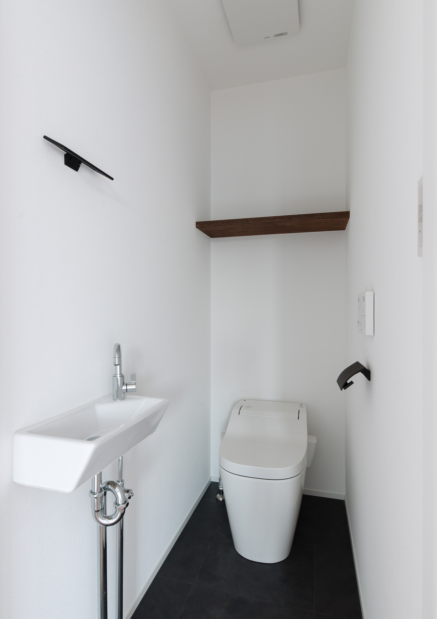 白い壁に白い薄型手洗いが取り付けられたトイレ・デザイン住宅 注文住宅・デザイン住宅建築実例_『CASE609 パーゴラの家』_トイレ