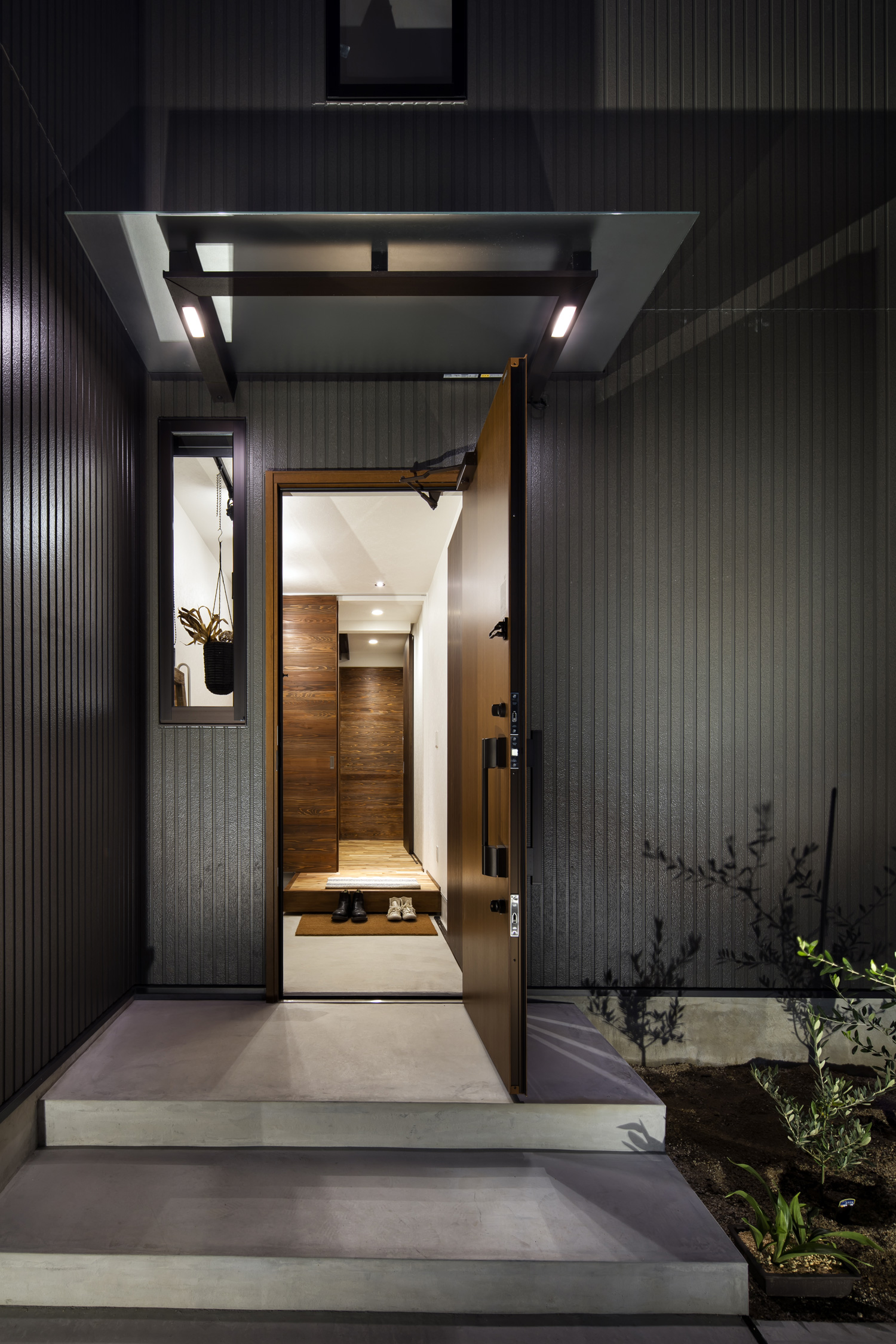 木製の玄関扉が開かれ室内が見える様子・デザイン住宅 注文住宅・デザイン住宅建築実例_『CASE610 Lagom hus　ちょうどいい家』_外観