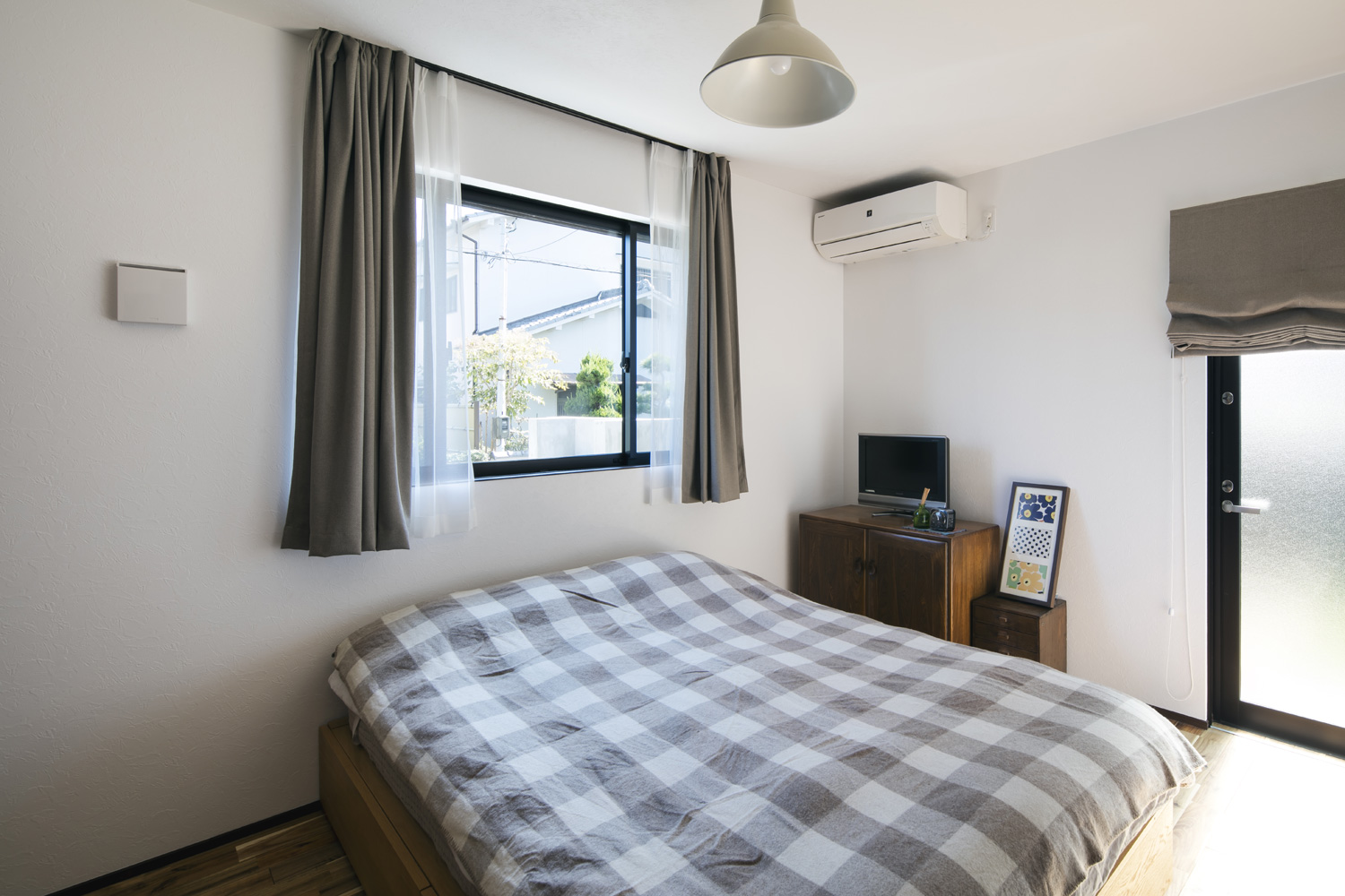 二方向に窓がある、チェック柄の毛布のベッドを置いた寝室・デザイン住宅 注文住宅・デザイン住宅建築実例_『CASE610 Lagom hus　ちょうどいい家』_寝室