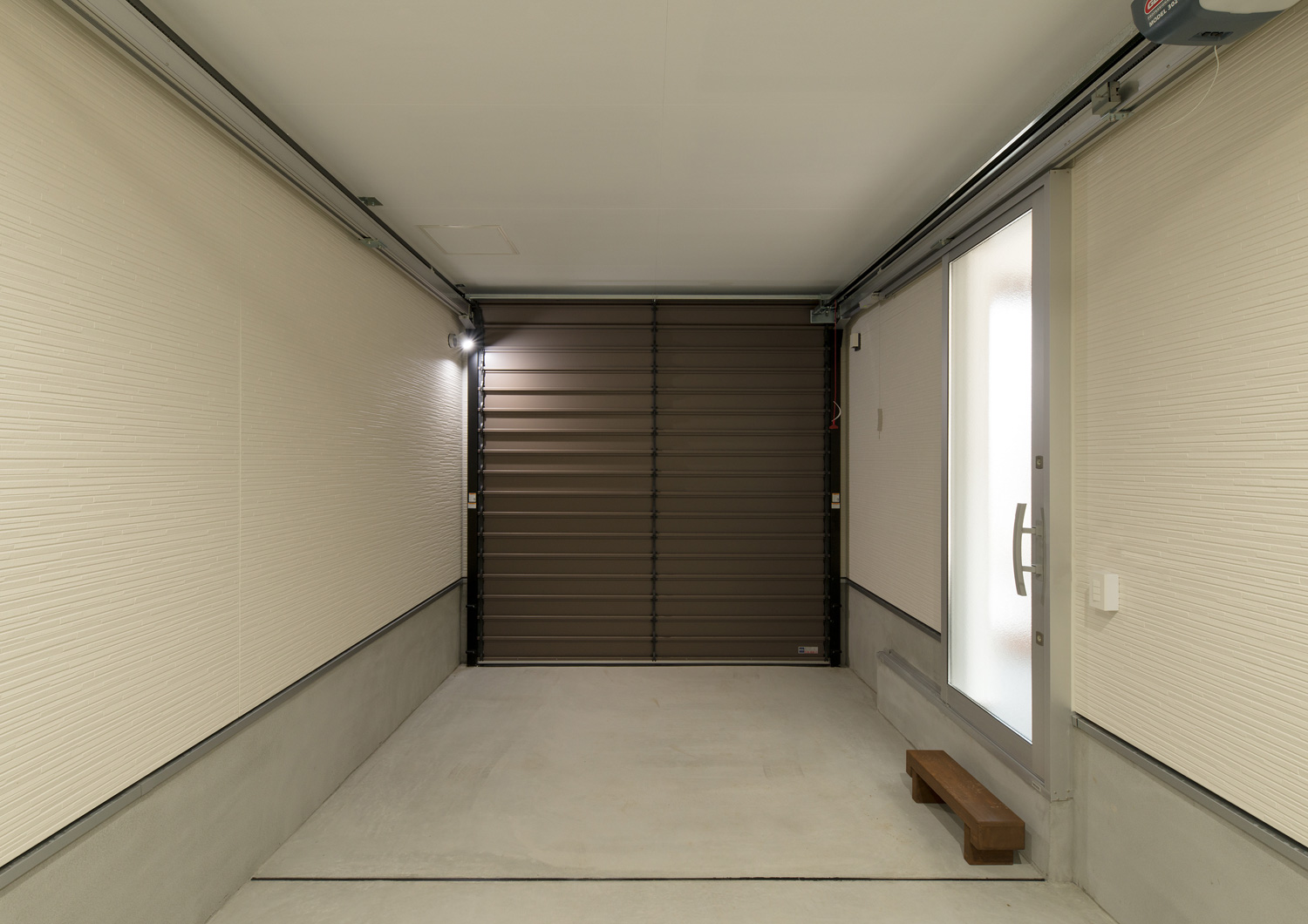 室内に繋がる扉があるシャッター付きのインナーガレージ・デザイン住宅 注文住宅・デザイン住宅建築実例_『CASE611 黒曜×石英』_ガレージ