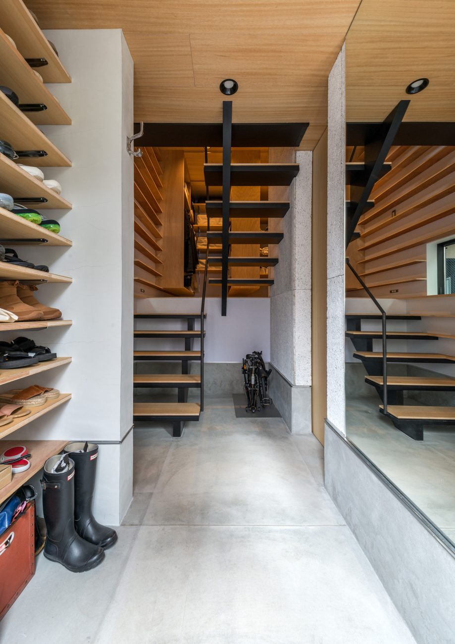 壁に靴が収納できる可動棚を取り付けた、正面にスケルトン階段がある土間の玄関・デザイン住宅 注文住宅・デザイン住宅建築実例_『CASE612 たなのいえ』_玄関