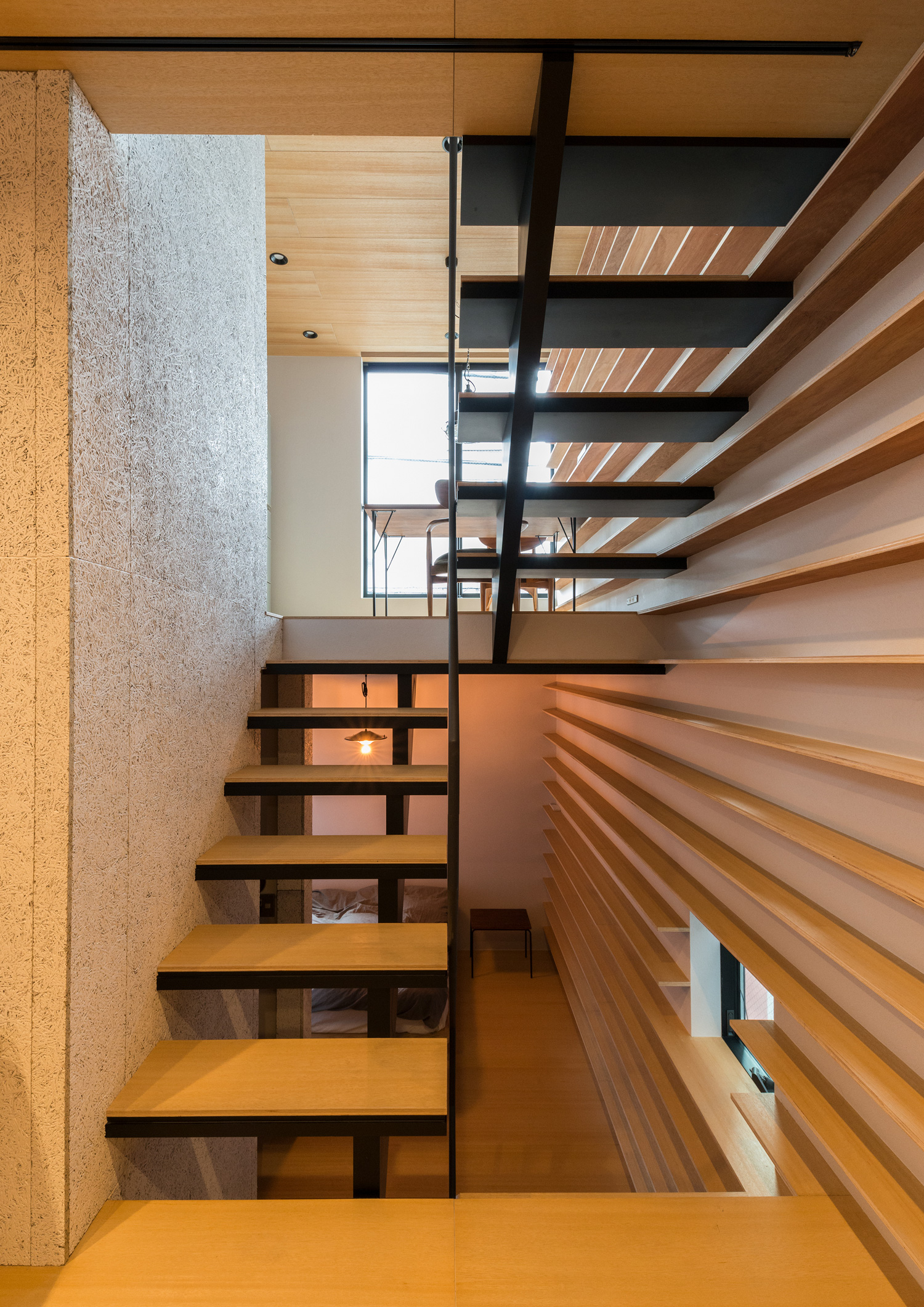 木製の棚が取り付けられた壁と木毛セメント板の壁に挟まれたスケルトン階段・デザイン住宅 注文住宅・デザイン住宅建築実例_『CASE612 たなのいえ』_階段