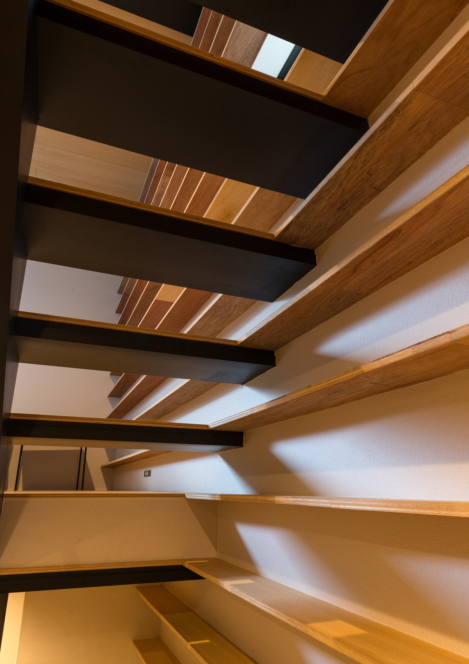 壁付けの棚と一体化するスケルトン階段を下から見た様子・デザイン住宅 注文住宅・デザイン住宅建築実例_『CASE612 たなのいえ』_階段