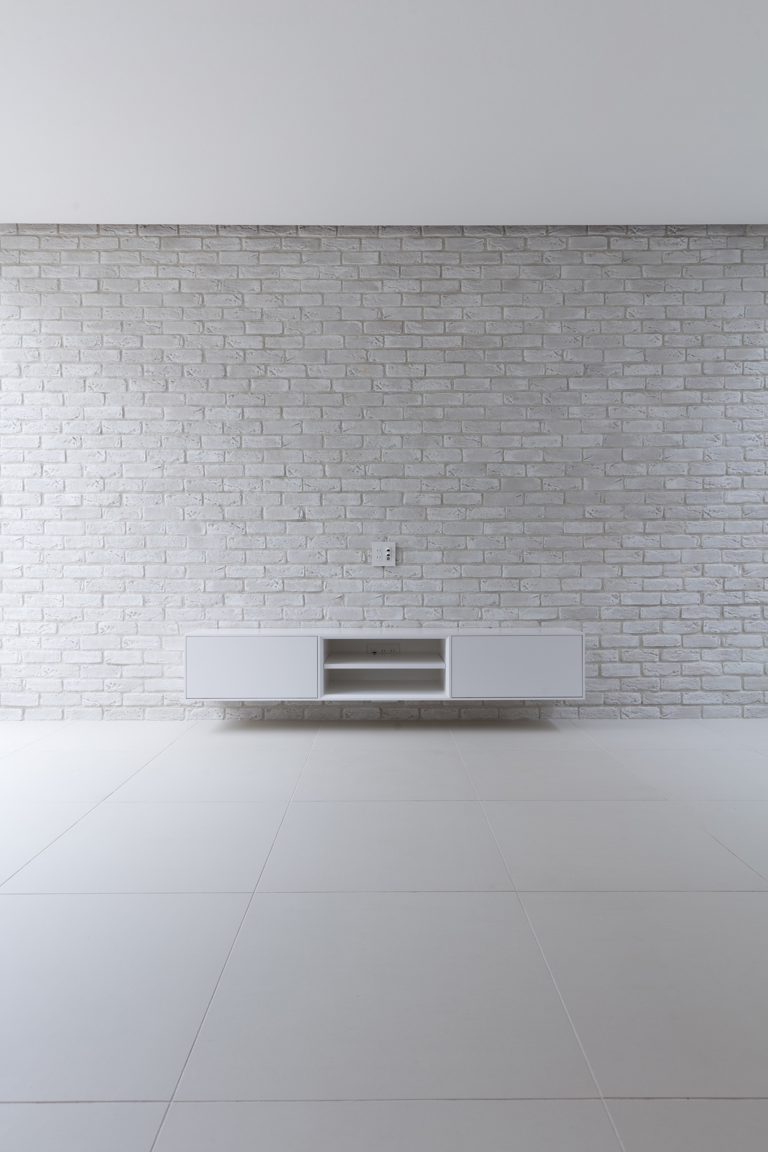 白いタイルのアクセントウォールの前に、白いテレビボードが置かれたLDK・デザイン住宅 注文住宅・デザイン住宅建築実例_『CASE616 HOUSE.FLOAT』_LDK