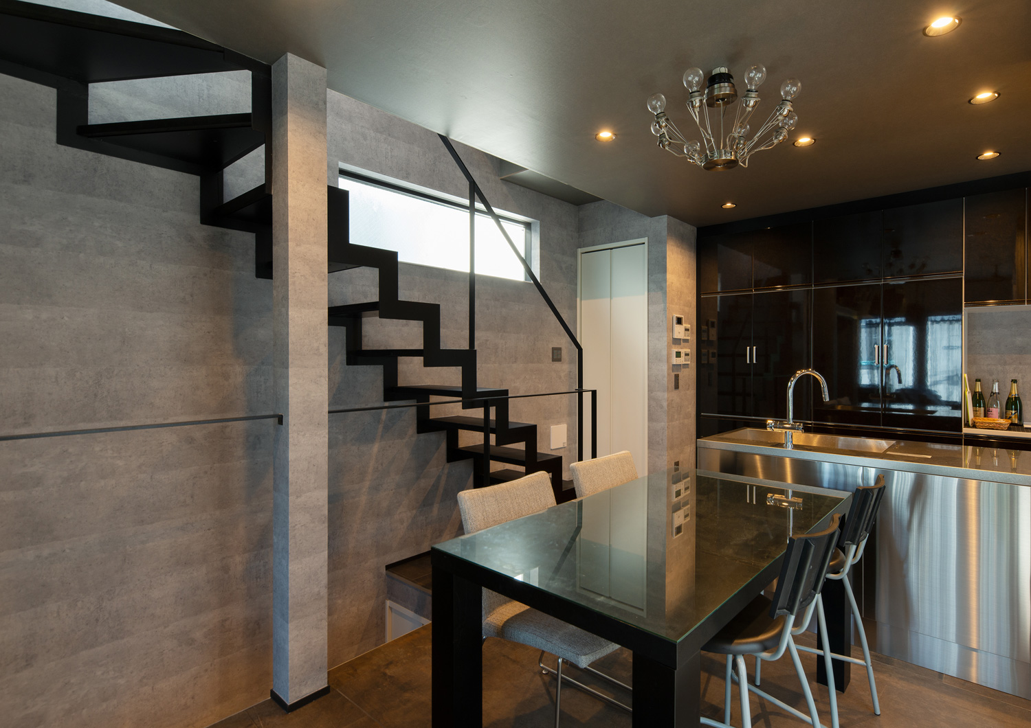 ステンレスのカウンターキッチンの前に黒いダイニングテーブルがある、スケルトン階段のあるLDK・デザイン住宅 注文住宅・デザイン住宅建築実例_『CASE617 Casa di Nero』_LDK