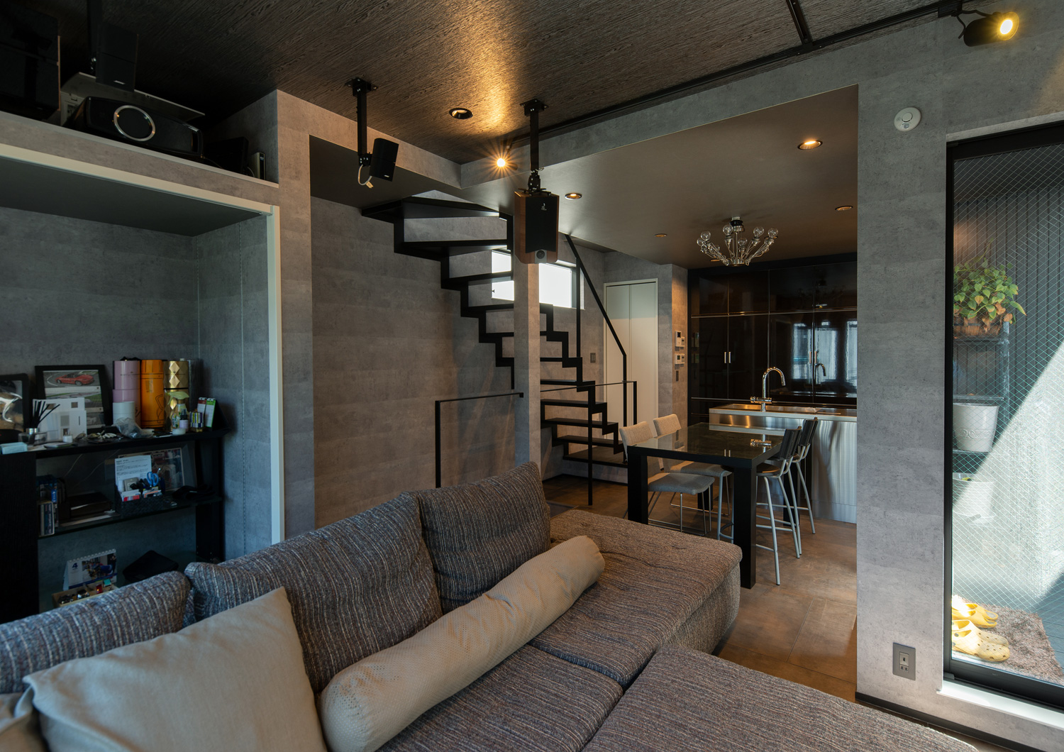 グレーの壁紙で、グレーのL字ソファーが置かれたアイアンのスケルトン階段があるLDK・デザイン住宅 注文住宅・デザイン住宅建築実例_『CASE617 Casa di Nero』_LDK