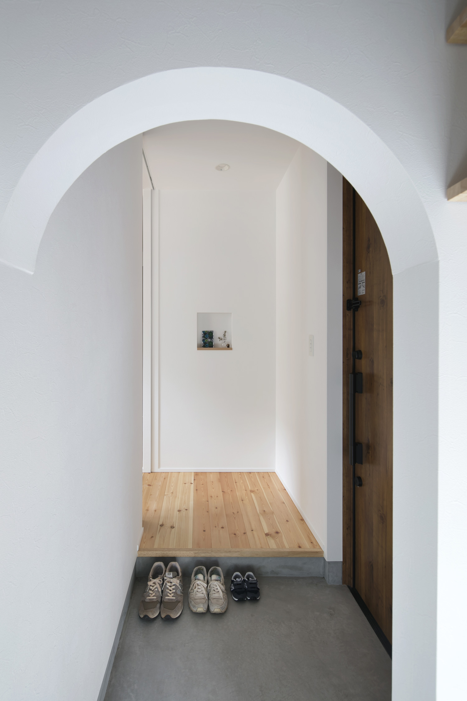 アーチ壁のあるモルタルの玄関・デザイン住宅 注文住宅・デザイン住宅建築実例_『CASE619 Hoccori』_玄関