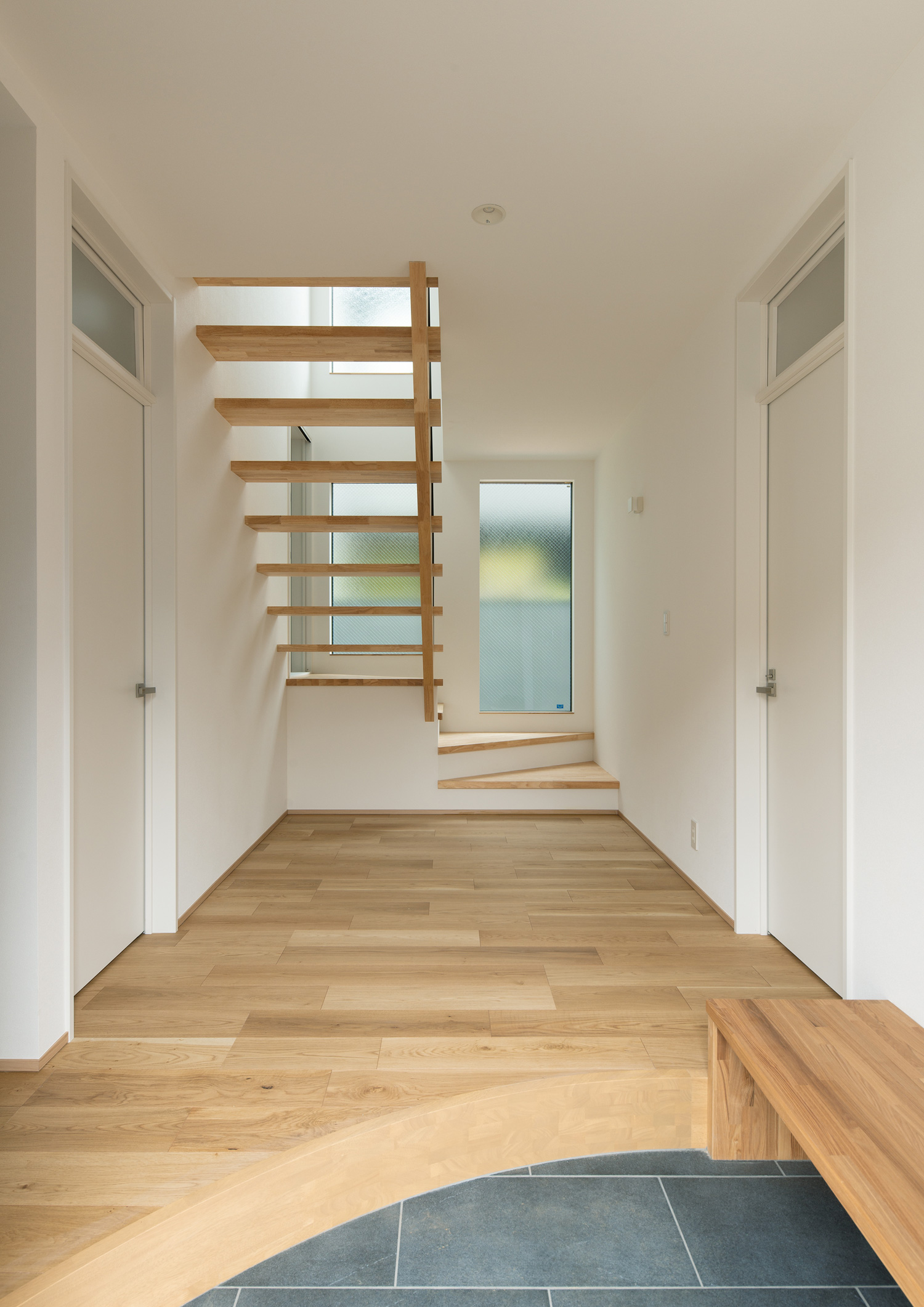 正面に窓とスケルトン階段のがる、ベンチ付きの玄関・デザイン住宅 注文住宅・デザイン住宅建築実例_『CASE620 継承する家』_玄関